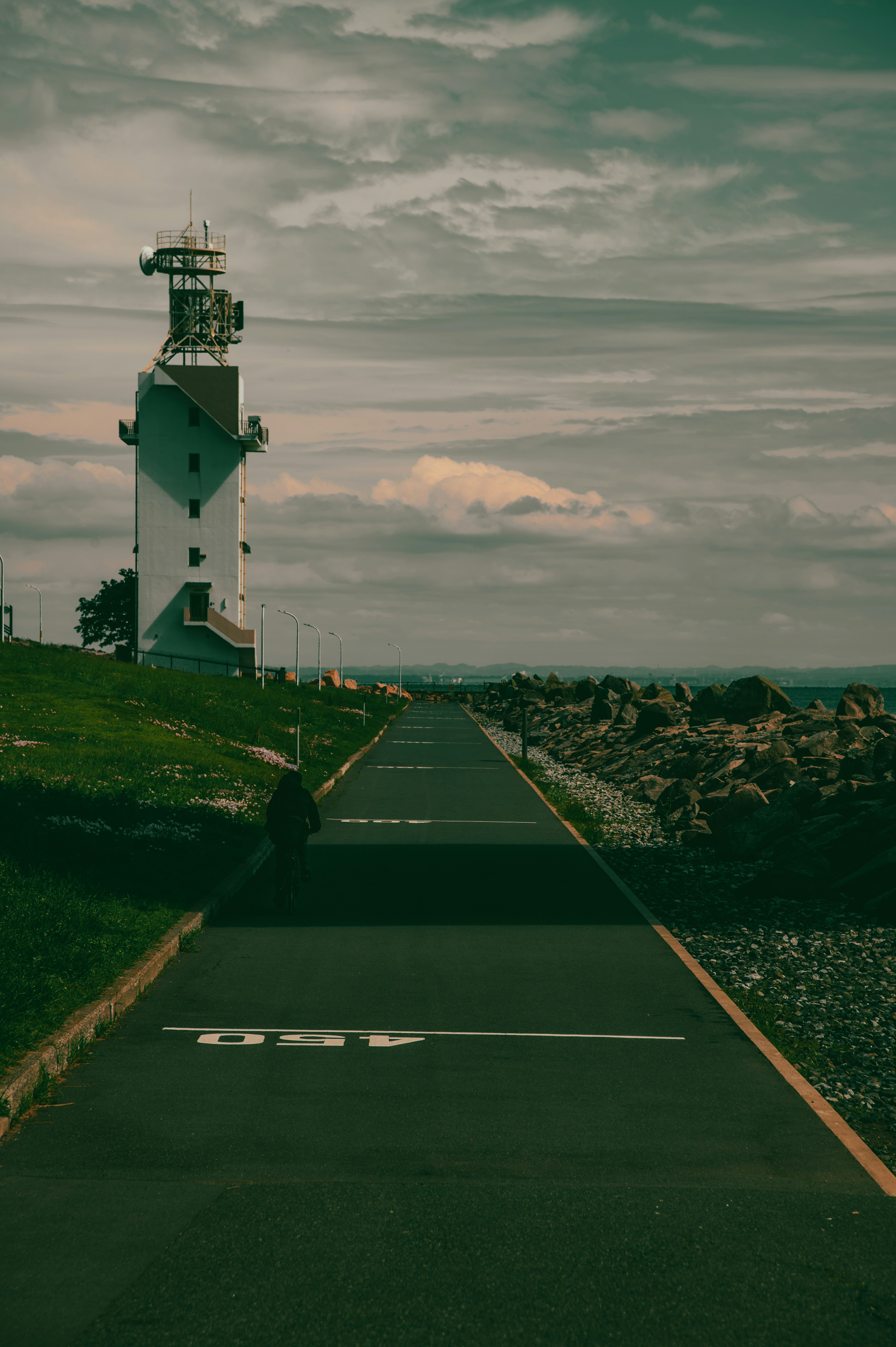 Landscape featuring a lighthouse and a paved road