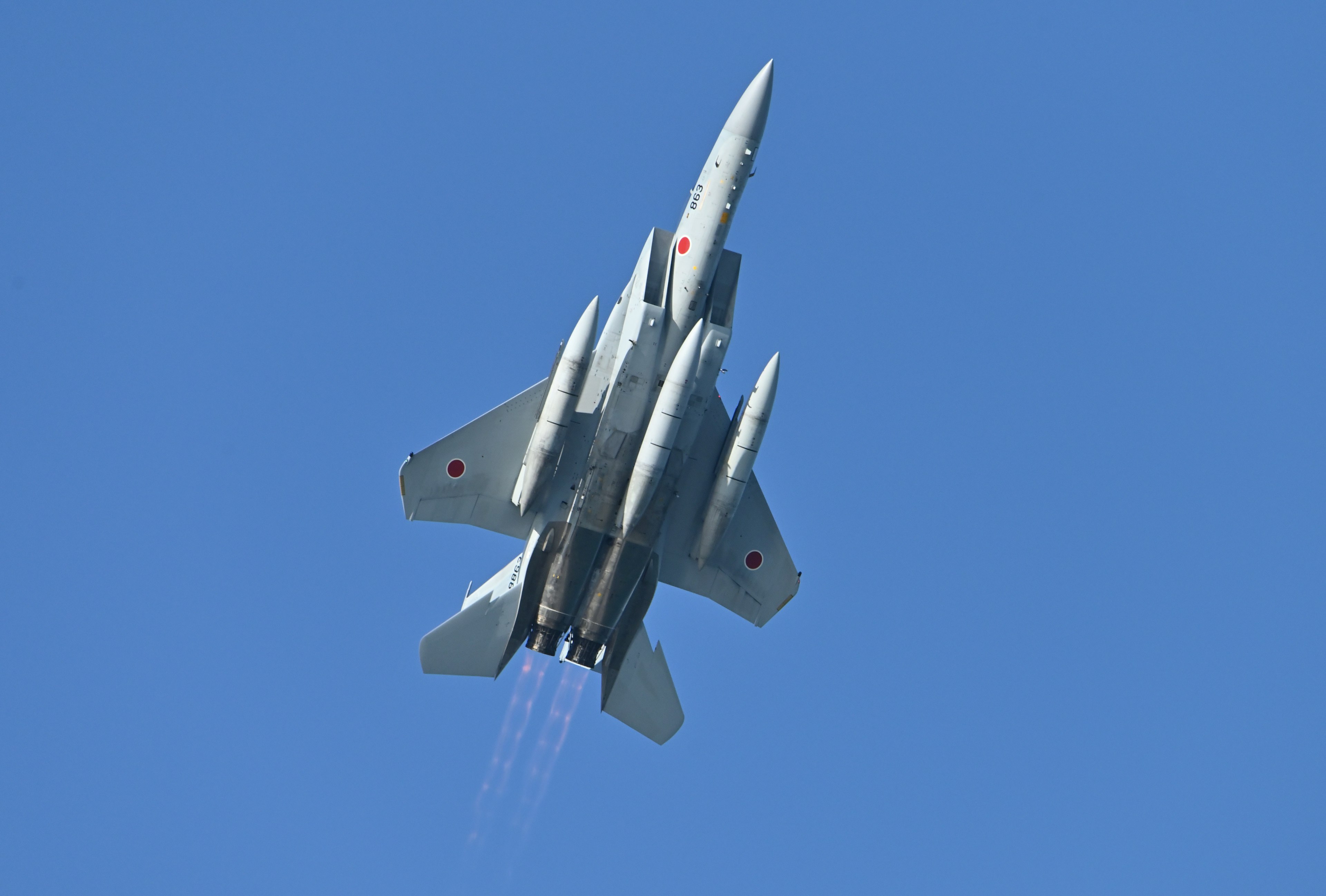 Fighter jet climbing into the blue sky