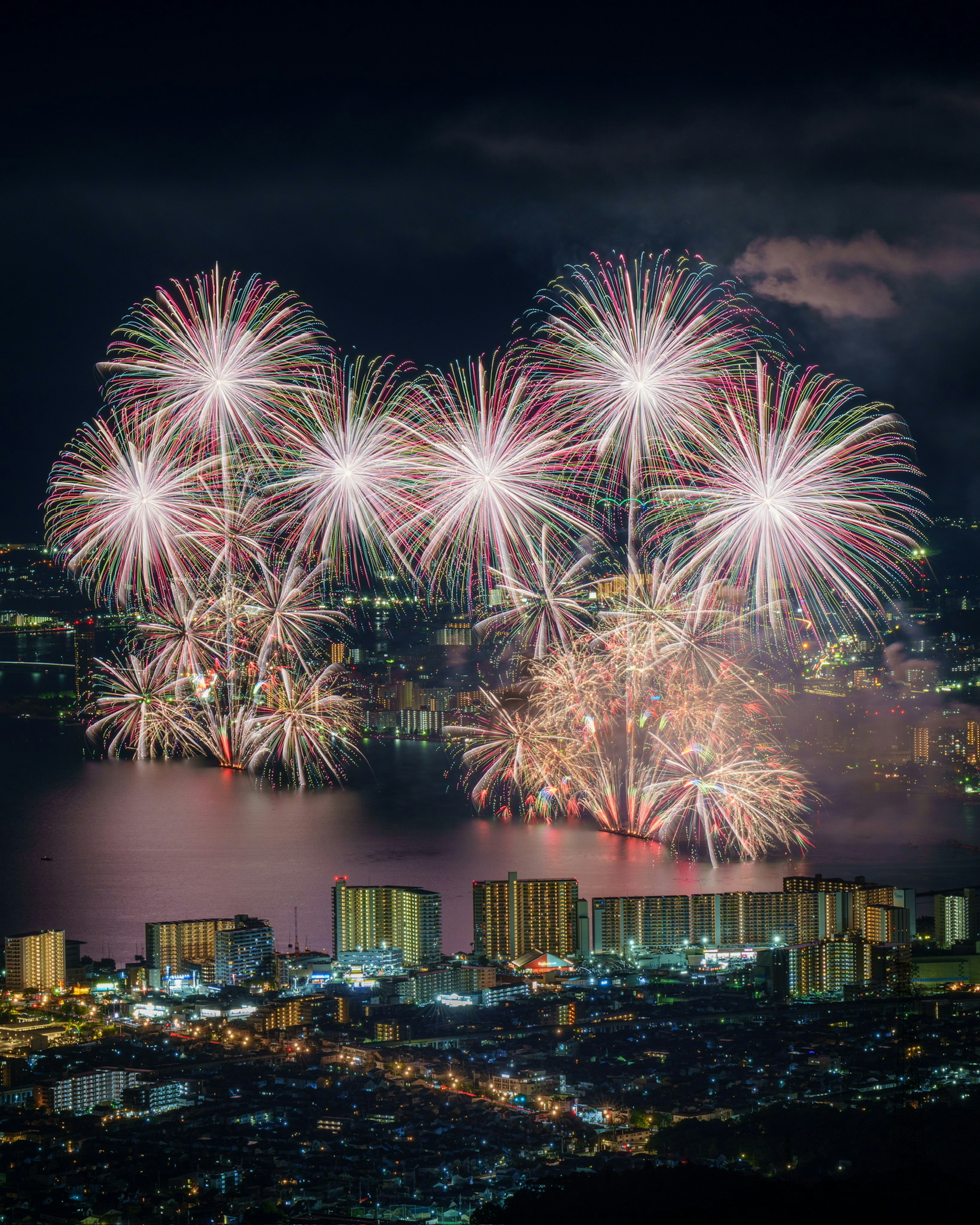 Un impresionante espectáculo de fuegos artificiales coloridos iluminando el cielo nocturno sobre un lago