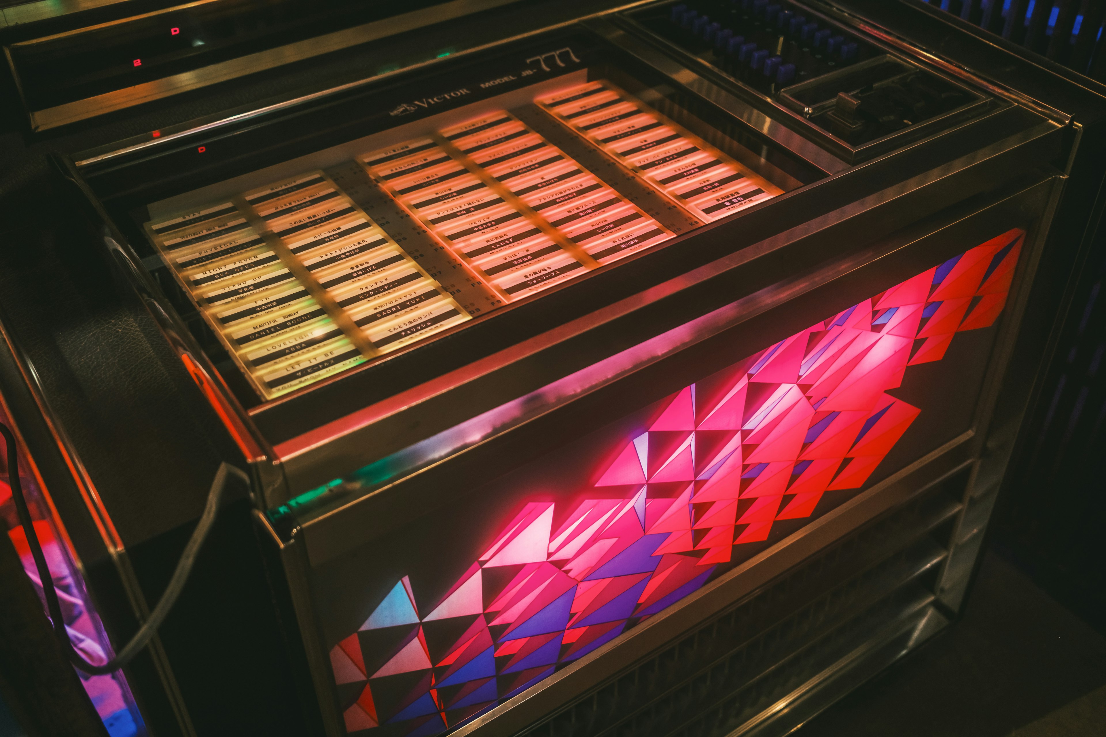 Một chiếc jukebox cổ điển với đèn nhiều màu sắc sáng ở phía trên