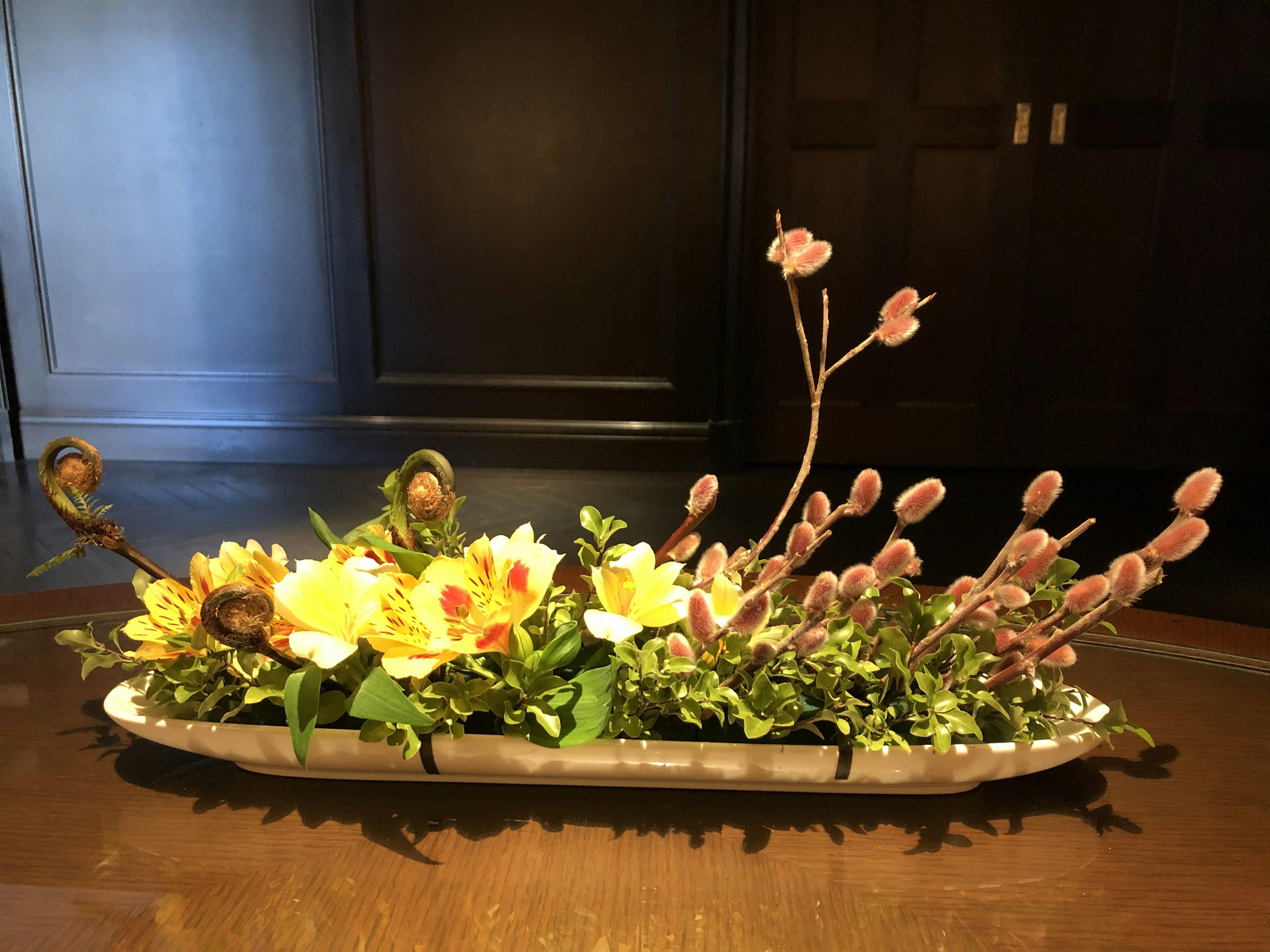 Flowing design floral arrangement featuring yellow and orange flowers