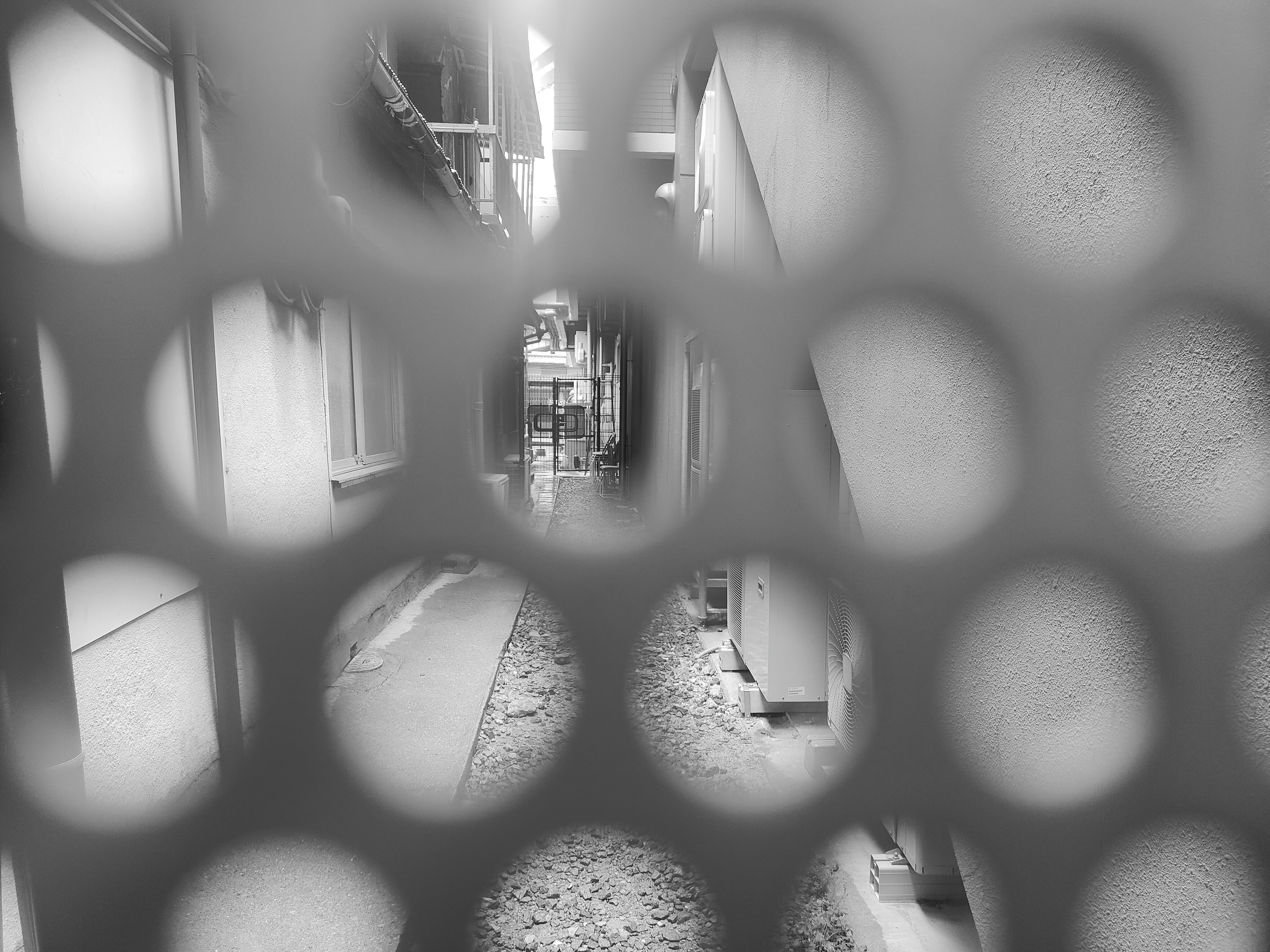 Monochrome alley view through circular holes