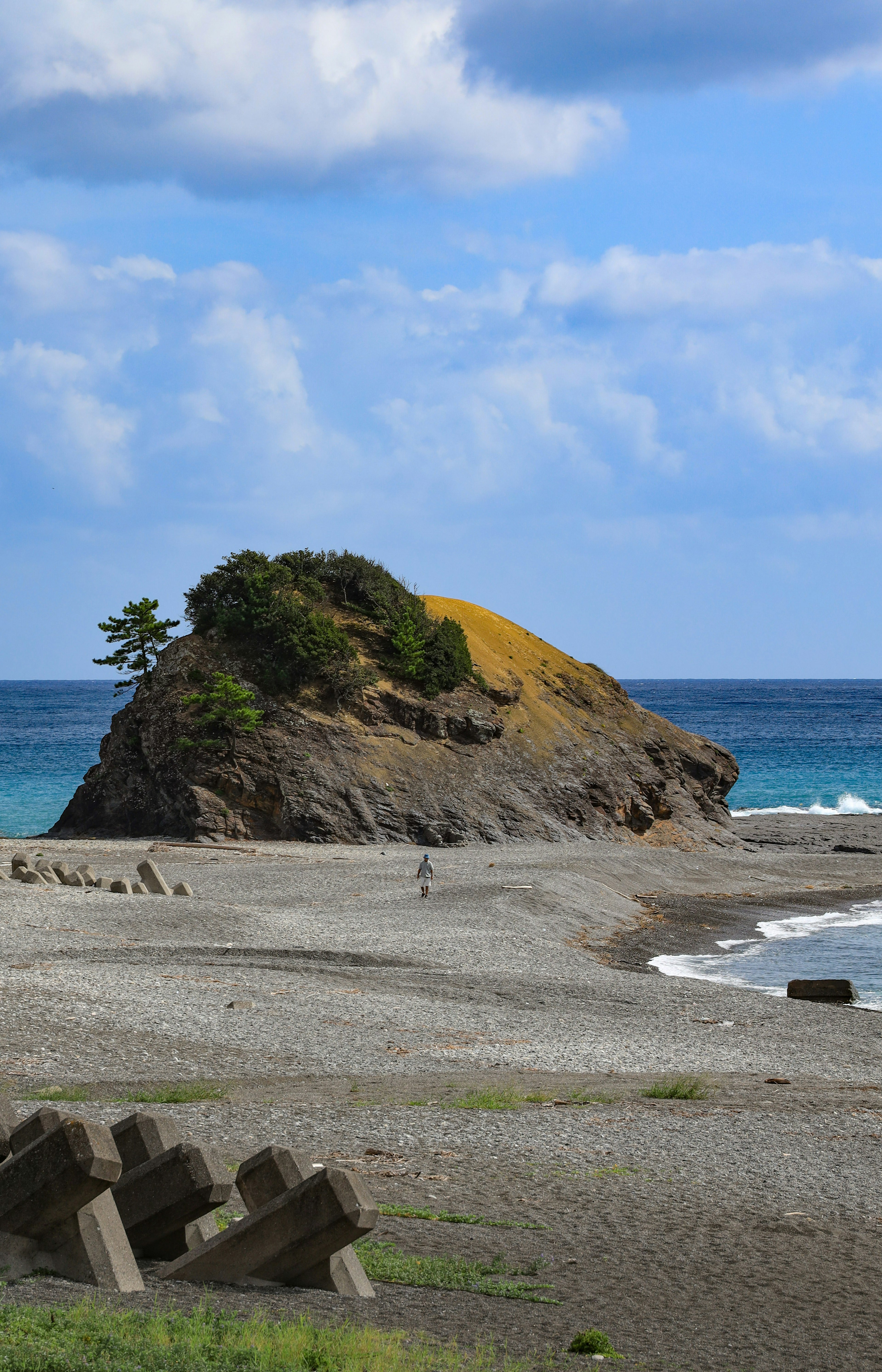 蓝色海洋和沙滩环绕的小岩石岛屿的风景