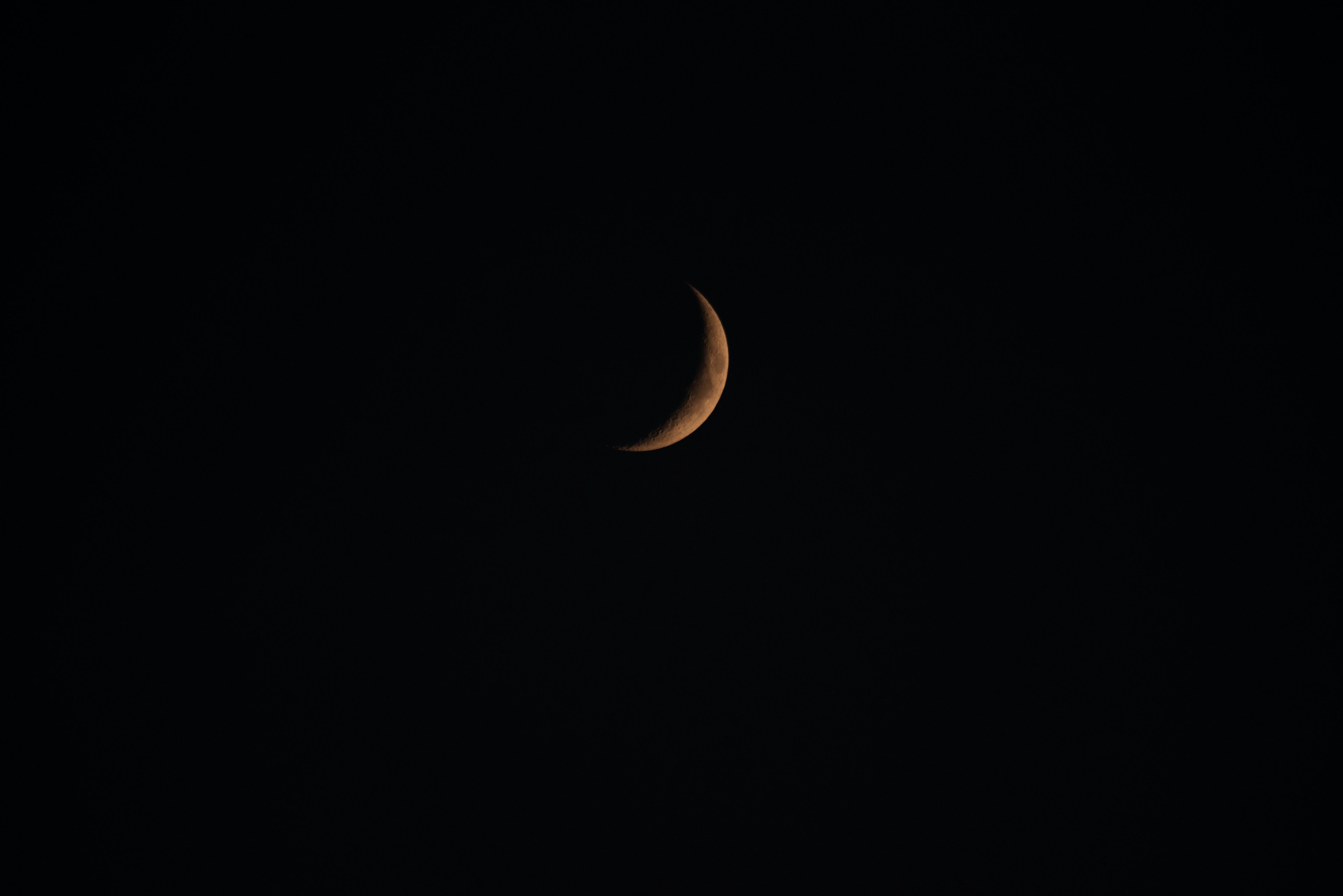 Sottile luna crescente nel buio cielo notturno