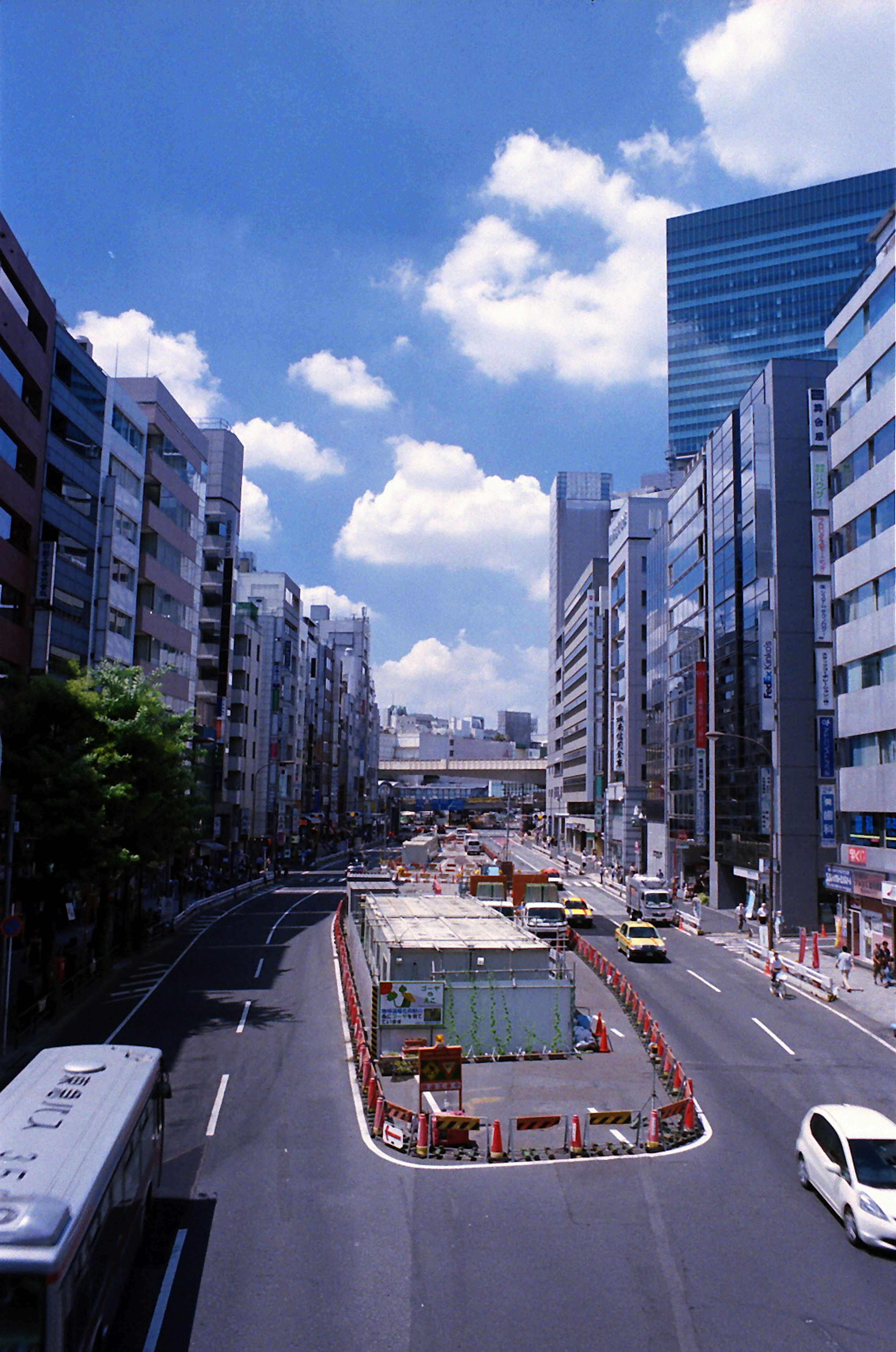 View of a city street lined with tall buildings and a blue sky