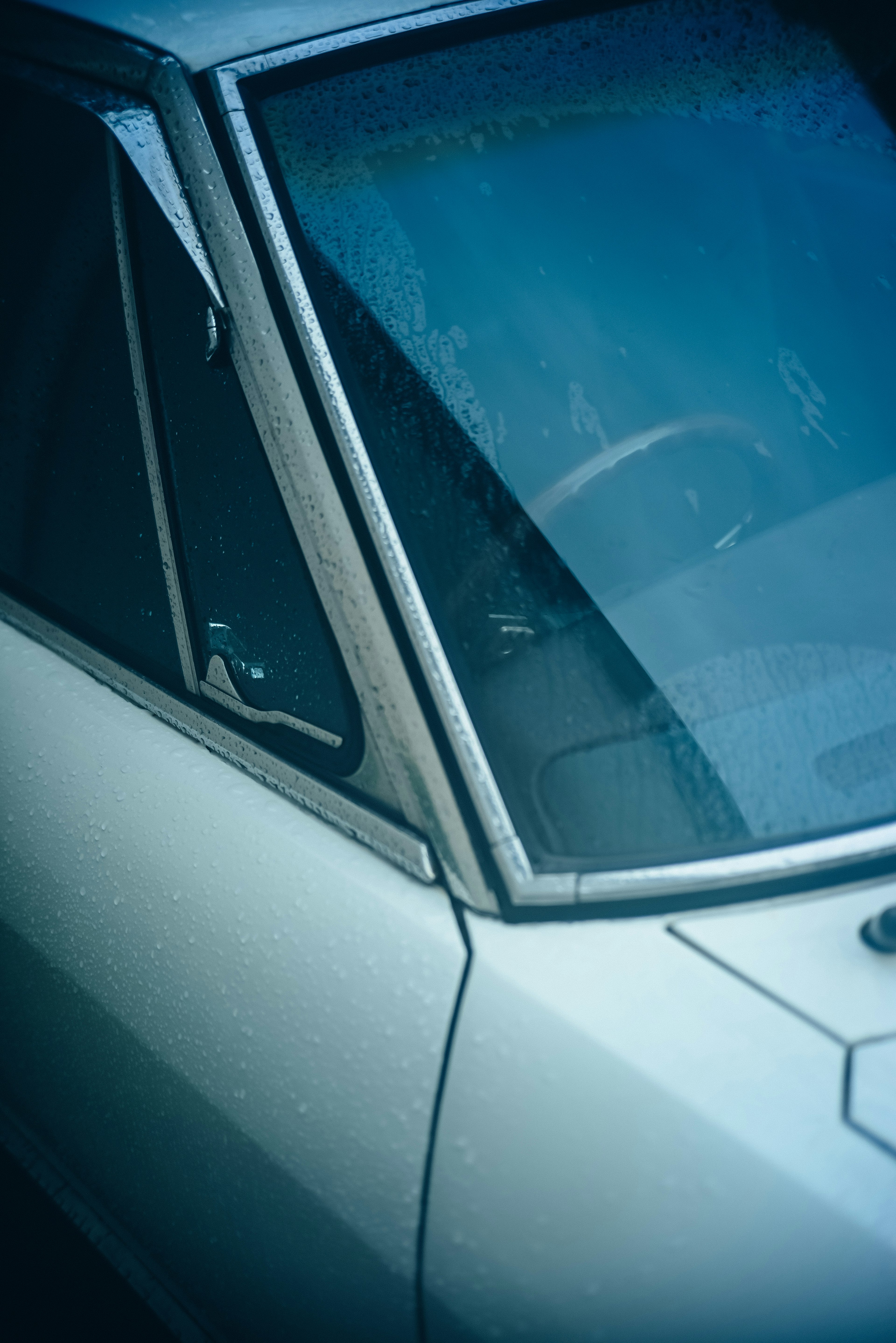 Primo piano di un finestrino di auto blu e volante