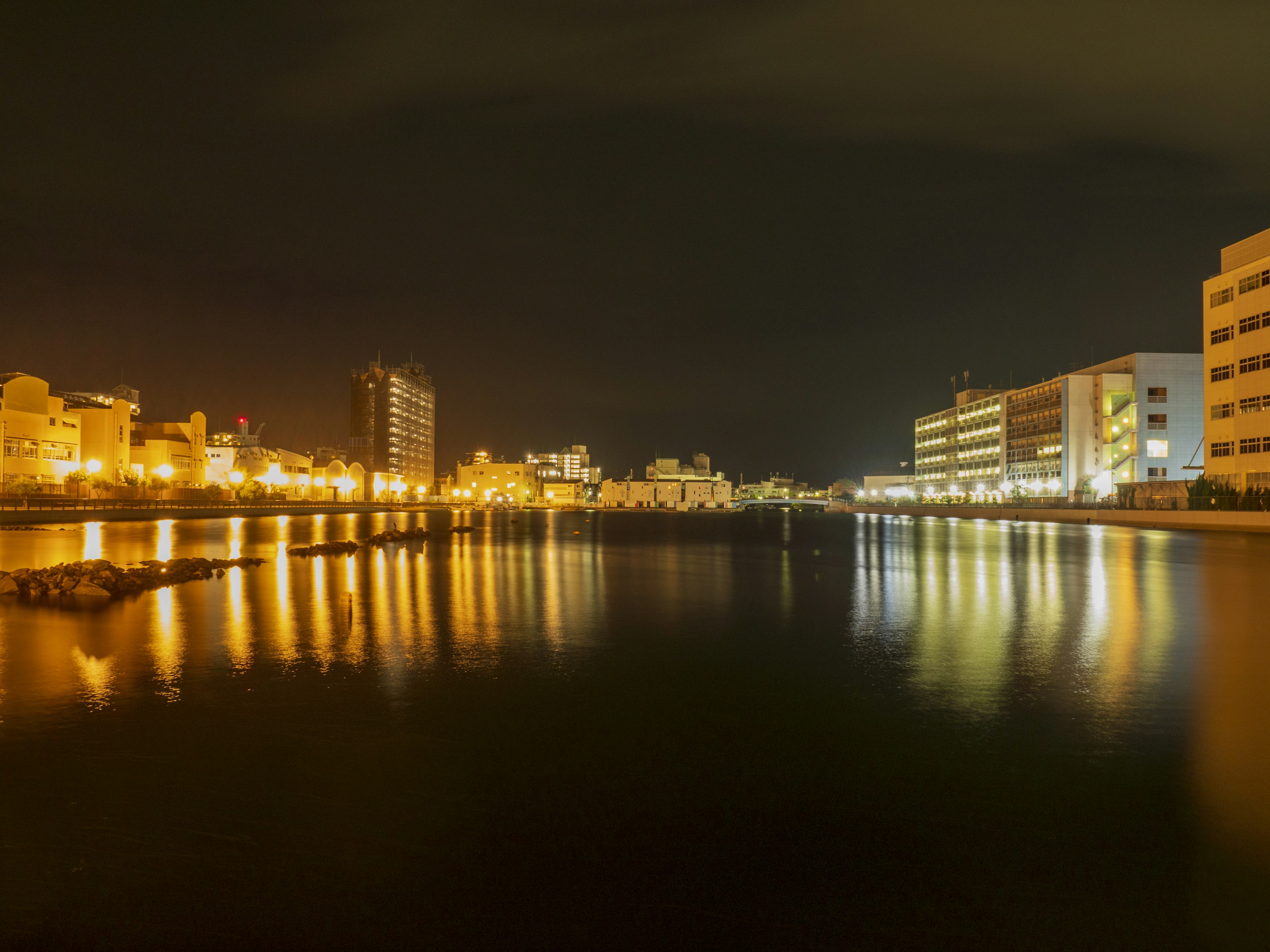 Night view of city buildings reflecting on the river