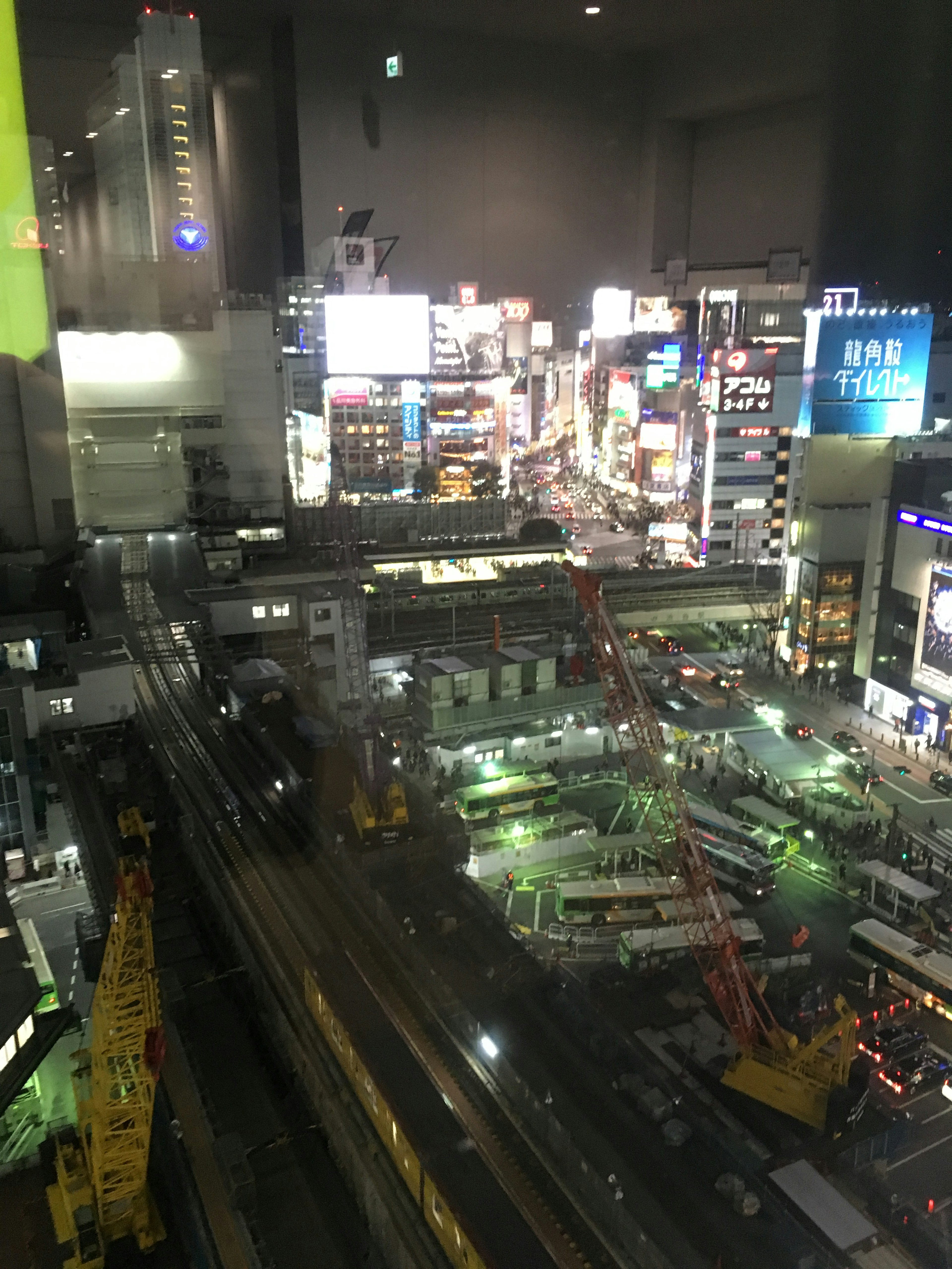 Paysage urbain nocturne avec des enseignes au néon brillantes et un chantier de construction