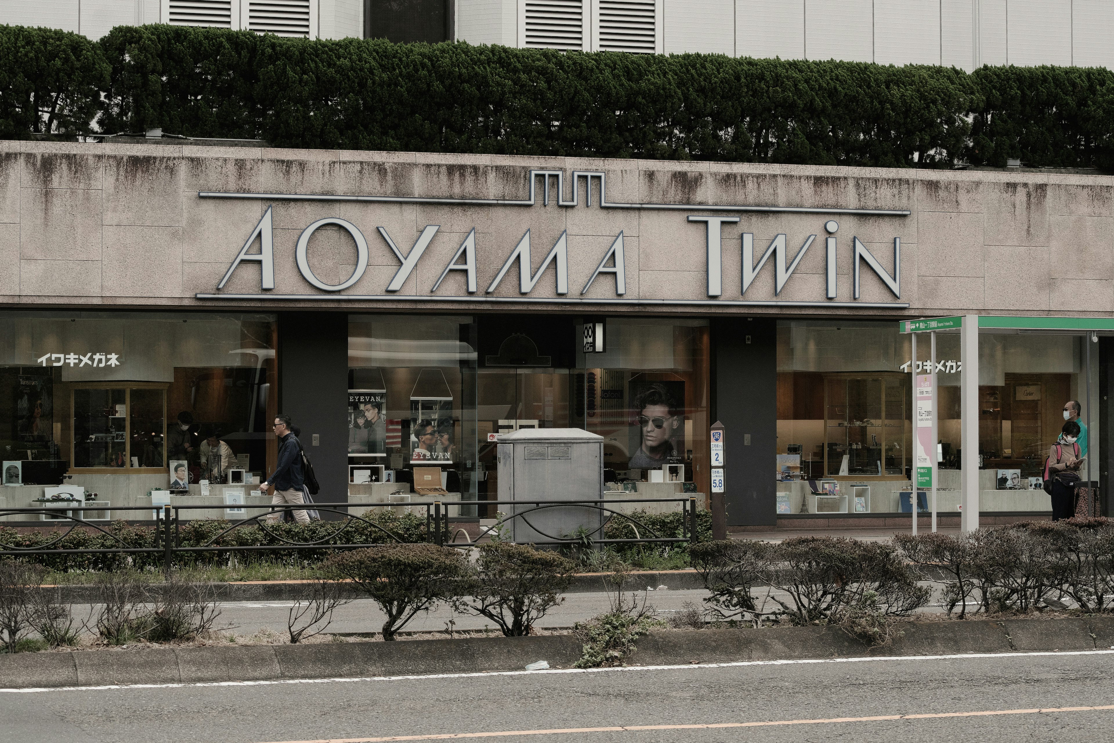 Vista exterior de la tienda Aoyama Twin con productos exhibidos en las ventanas de vidrio