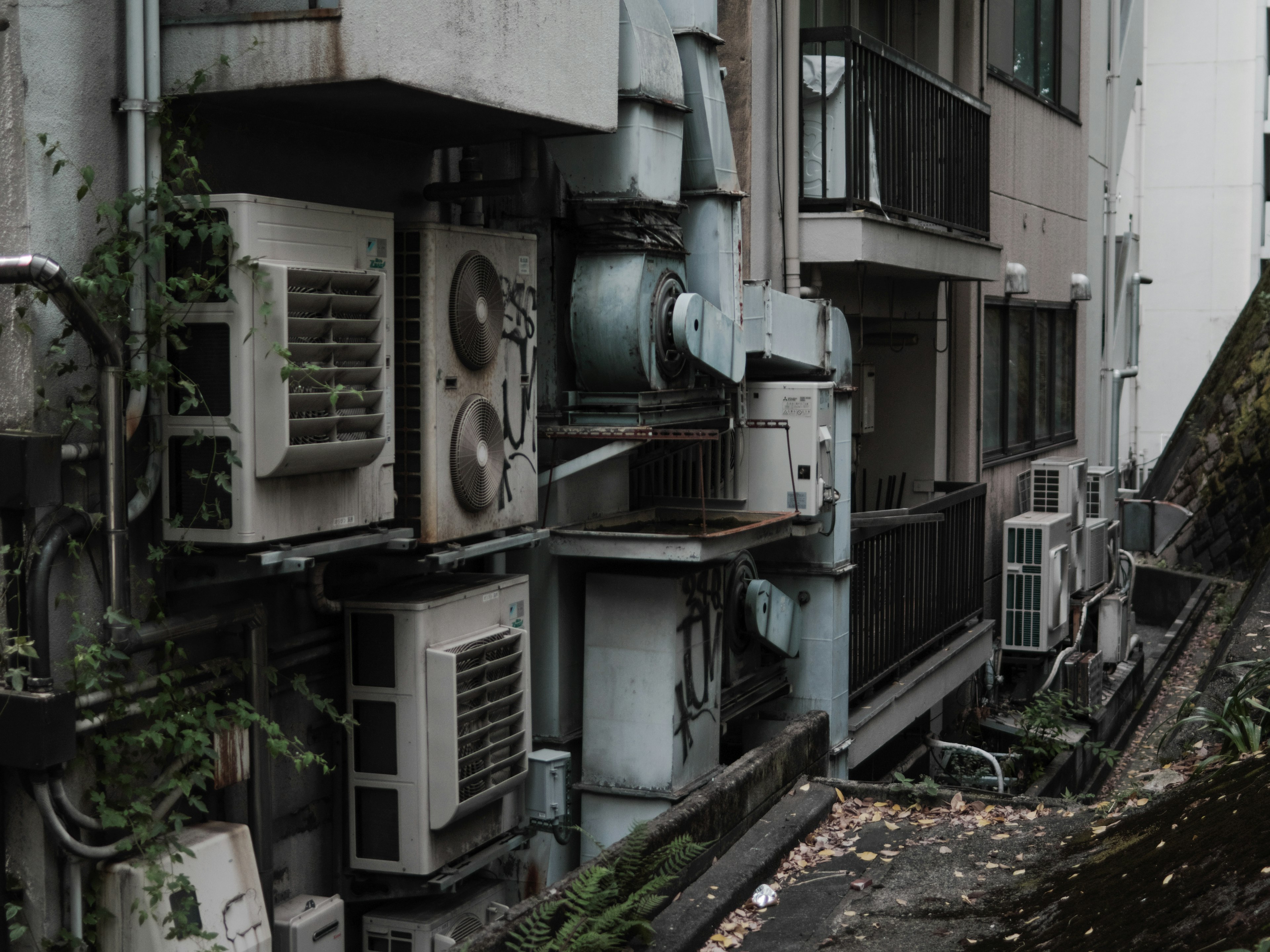 Allée étroite avec des unités de climatisation et l'extérieur d'un ancien bâtiment