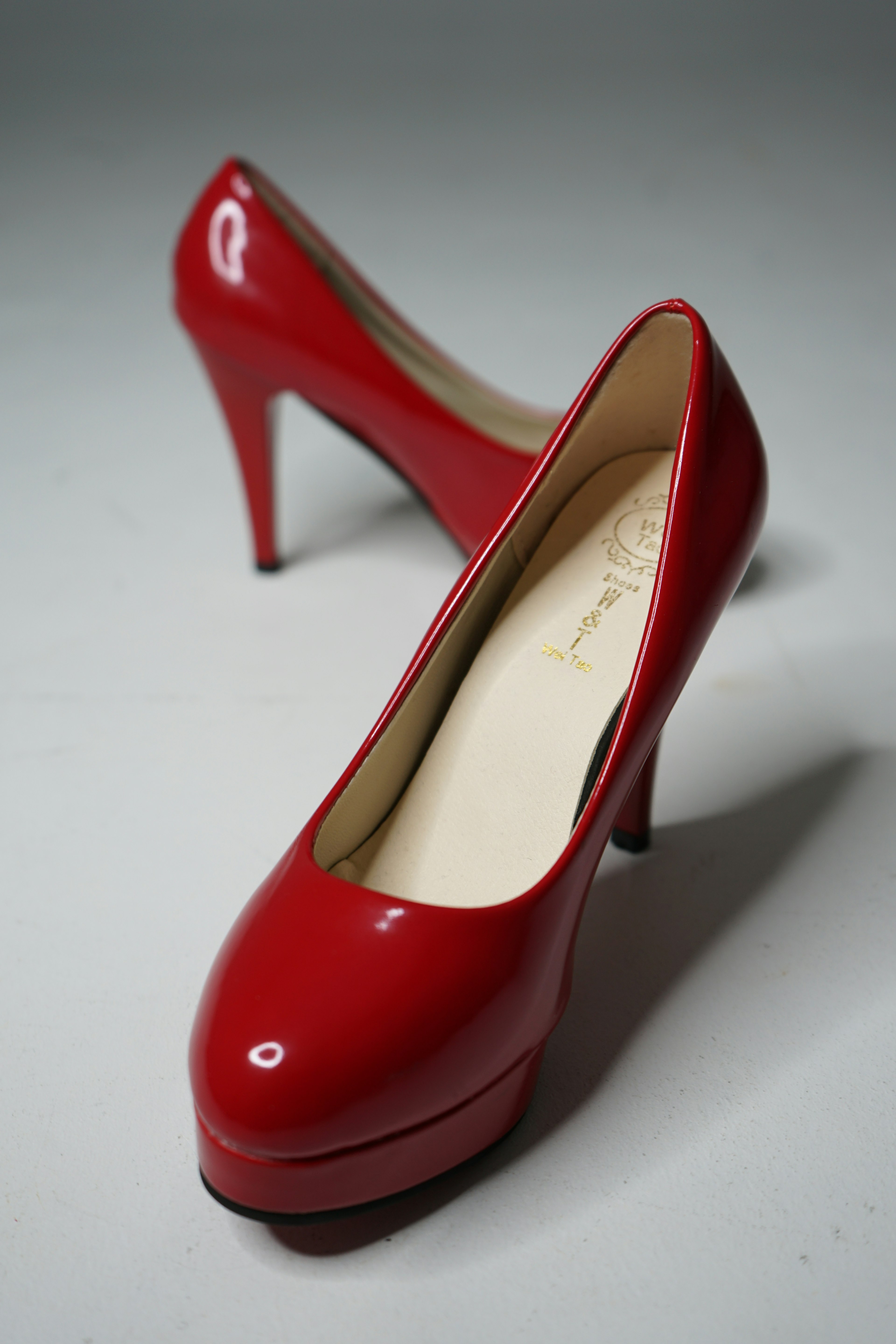 A pair of vibrant red high heel shoes positioned elegantly