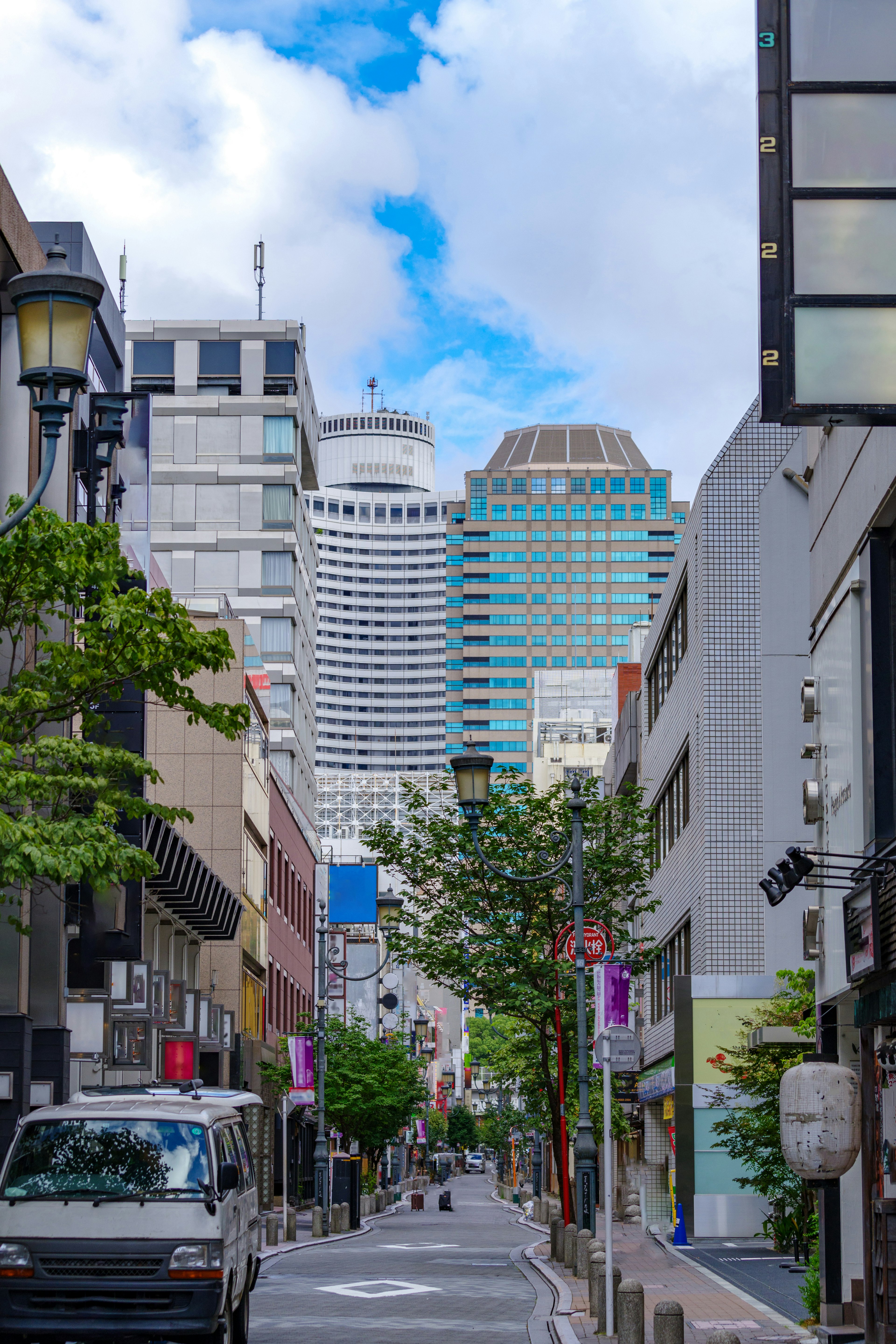 Urban street view featuring modern skyscrapers and greenery