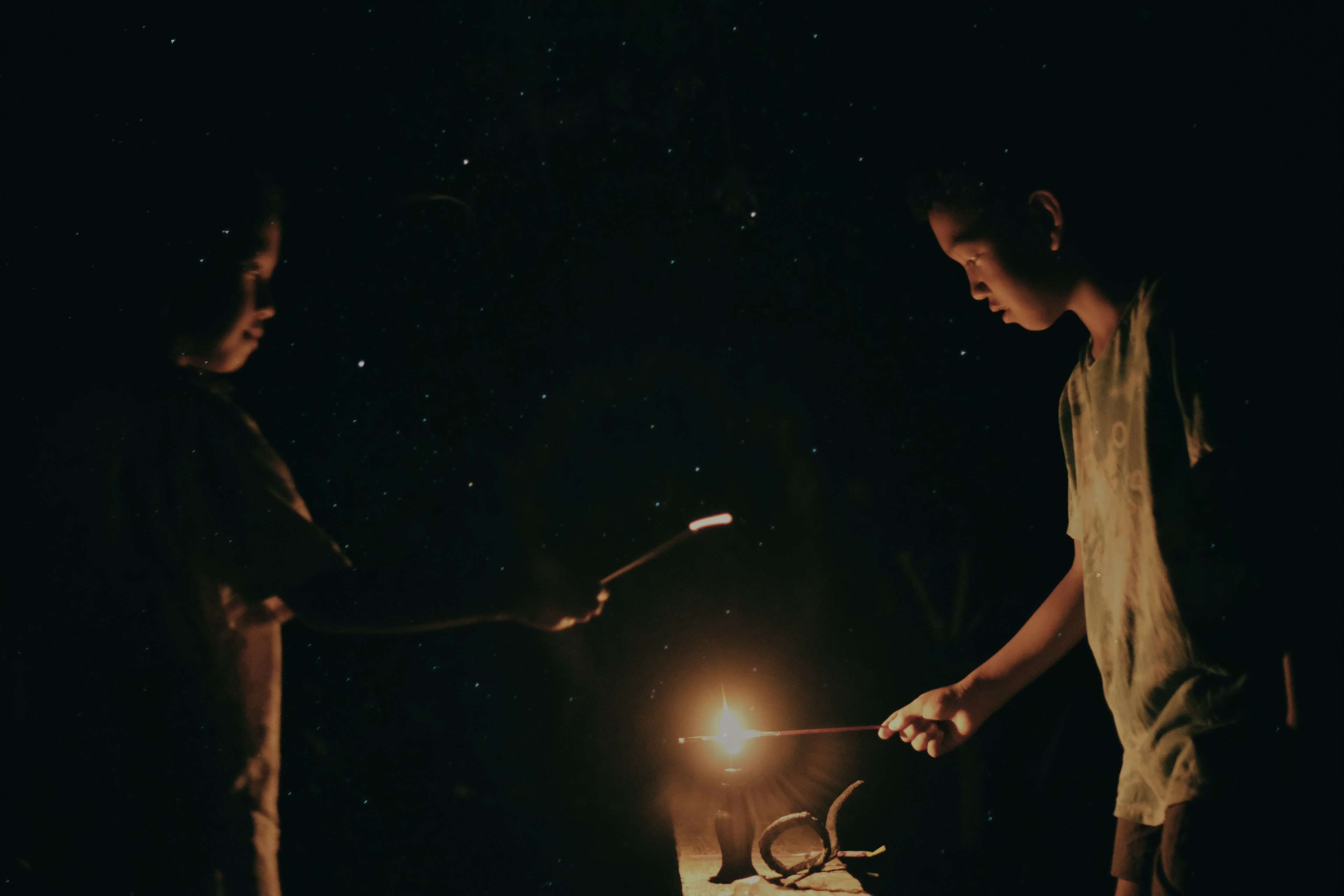 Dos niños creando chispas en la oscuridad