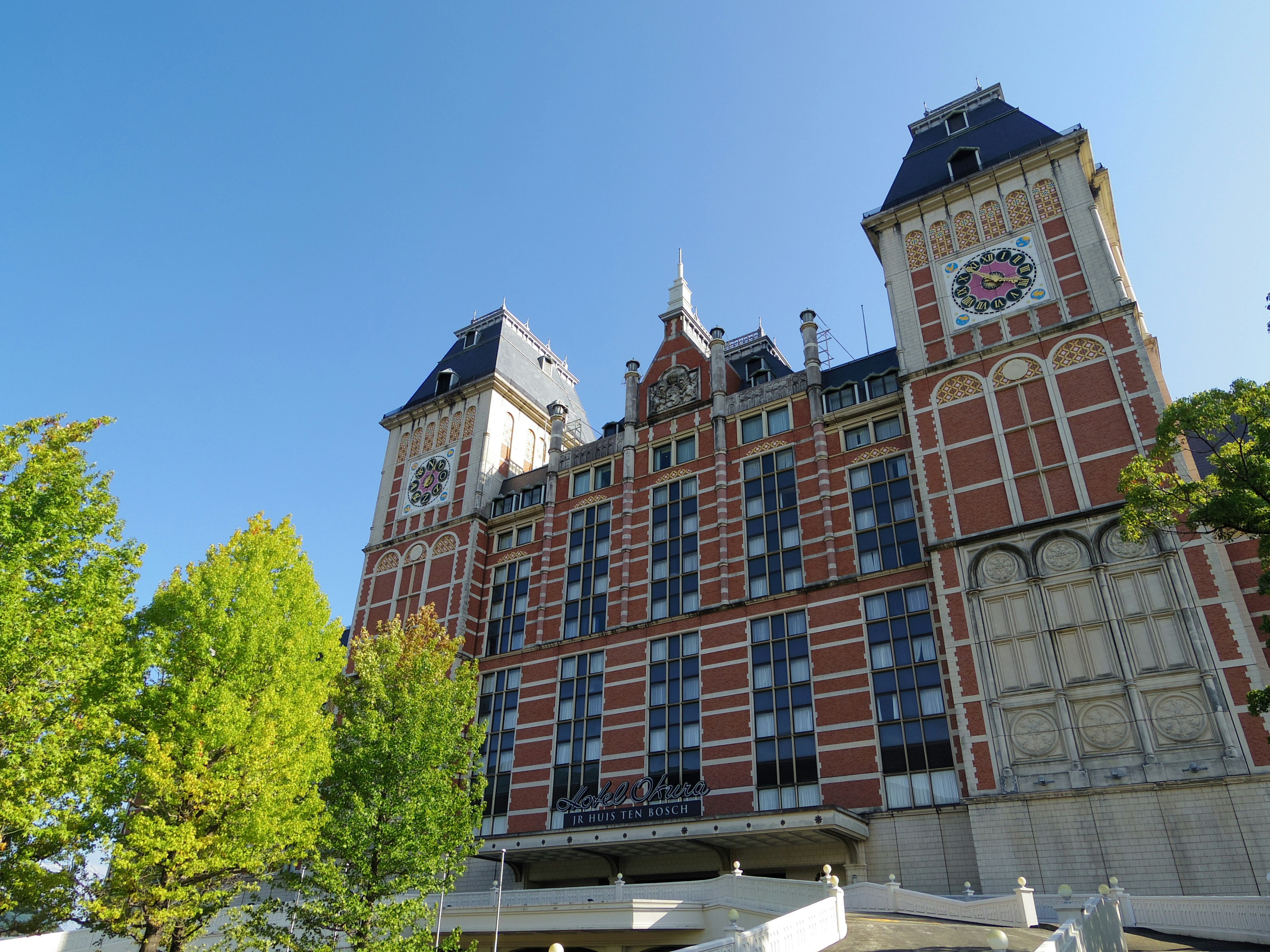 Bellissimo edificio in mattoni rossi con alberi verdi in primo piano