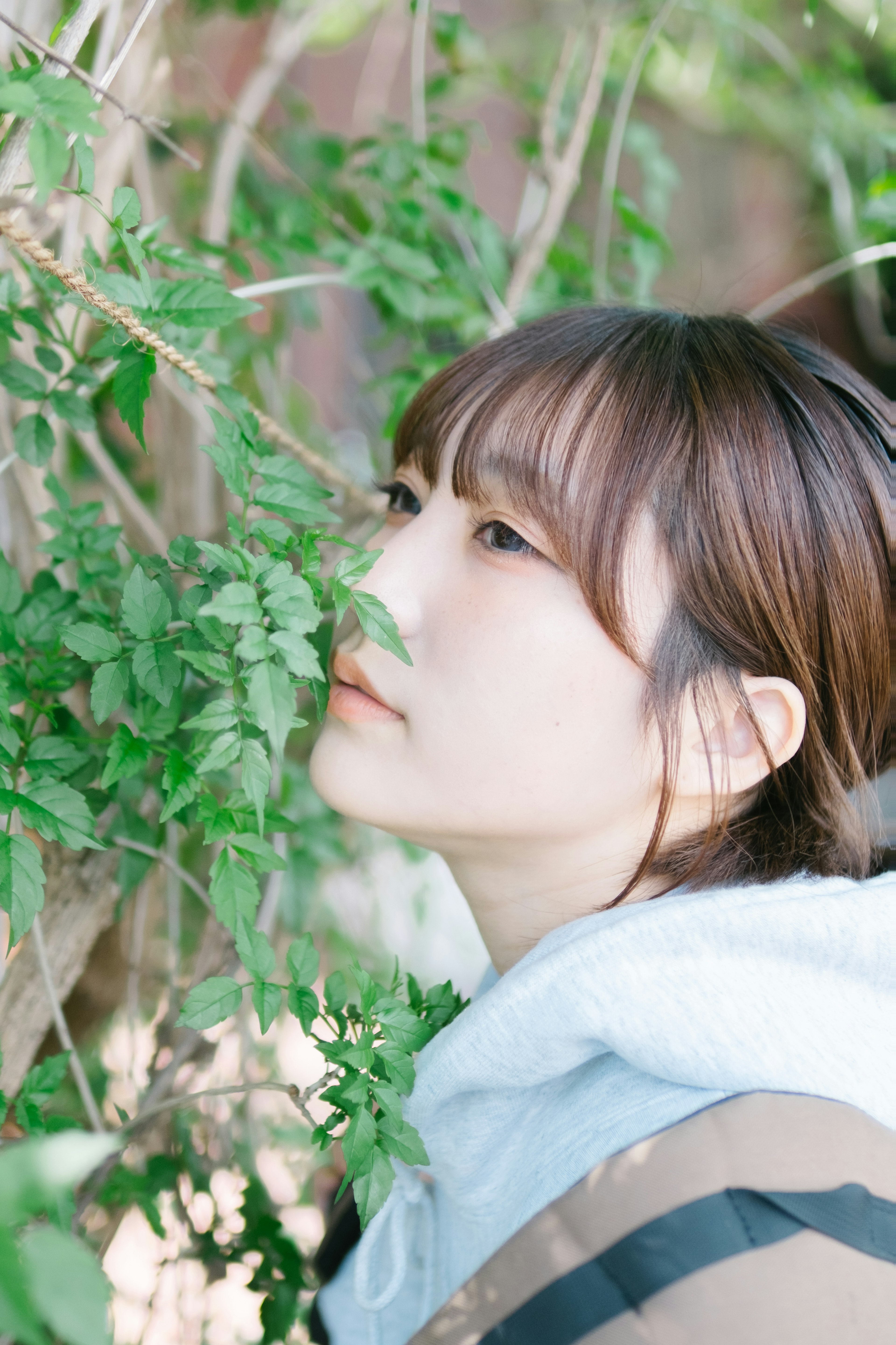 Joven mujer contemplativa cerca de plantas verdes