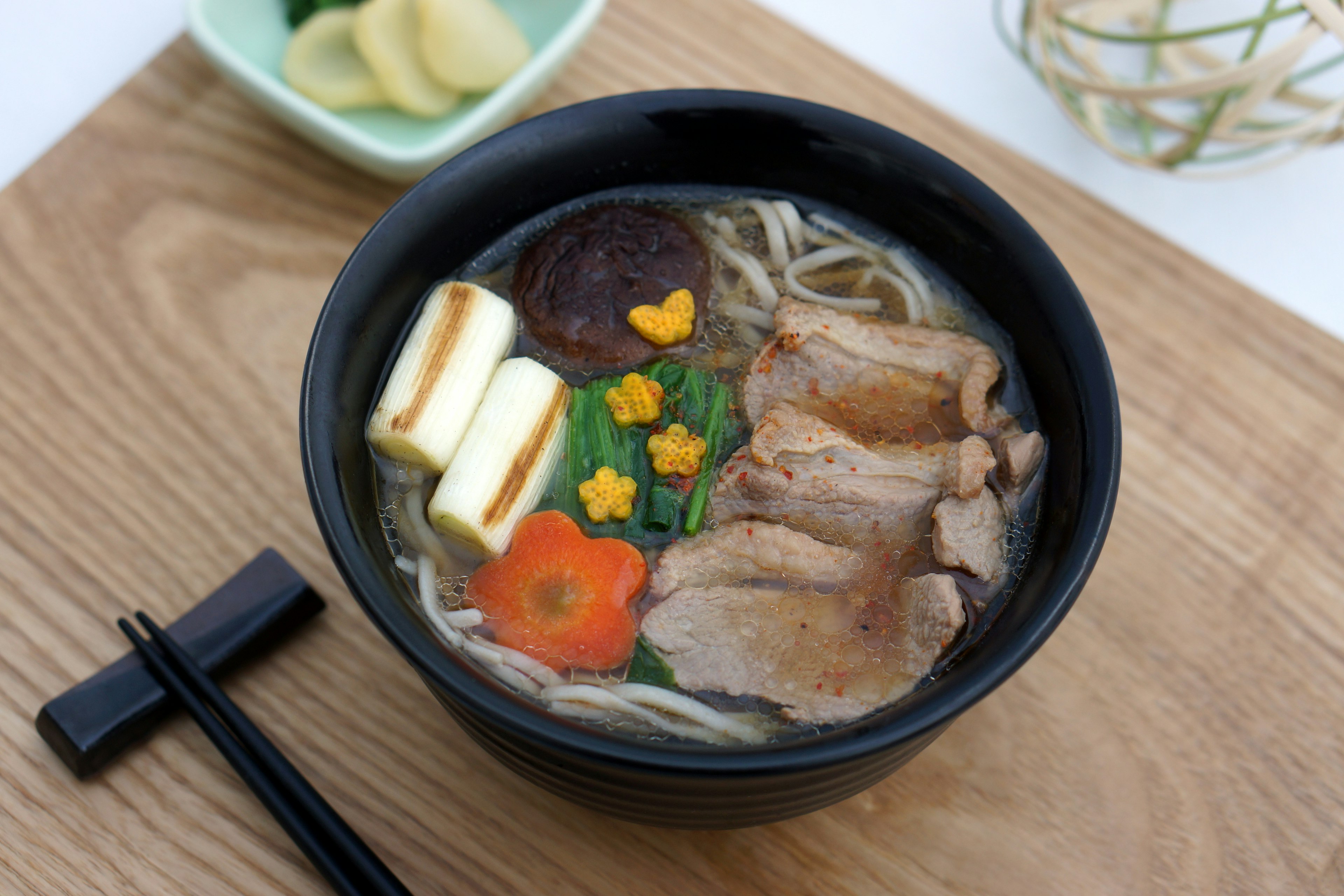 美しいラーメンボウルにスライスされた肉と野菜がトッピングされた料理