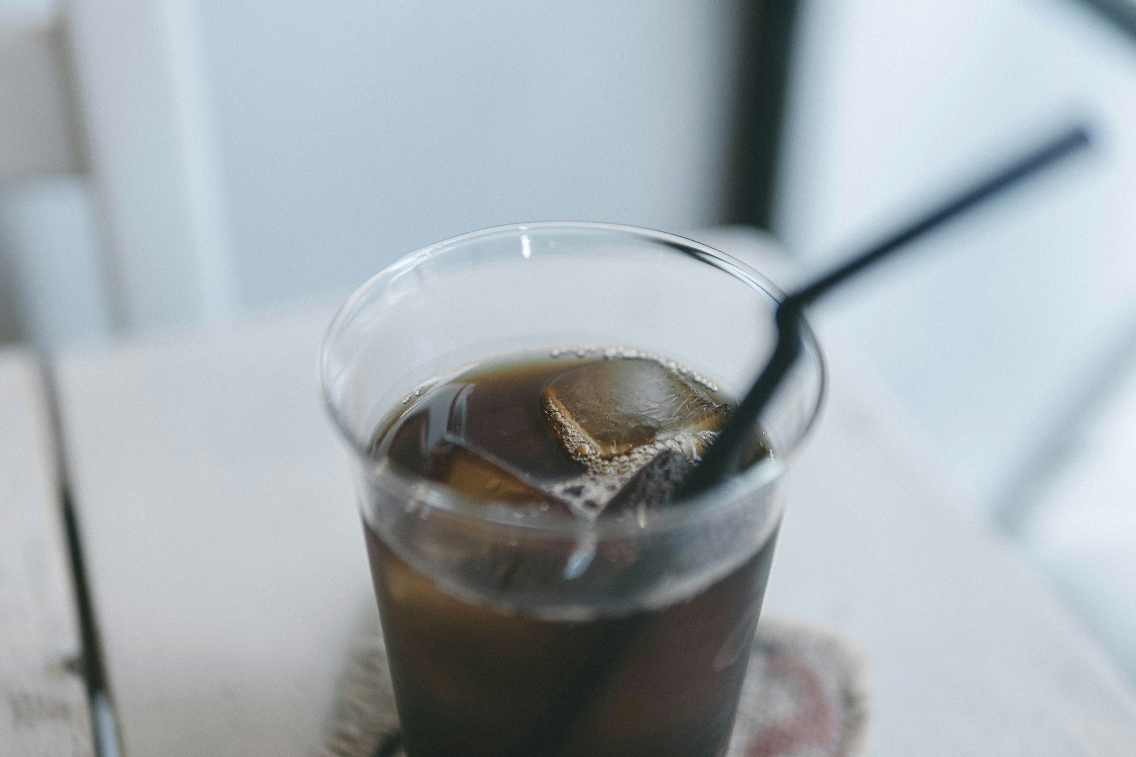 Café helado en un vaso transparente con una pajilla