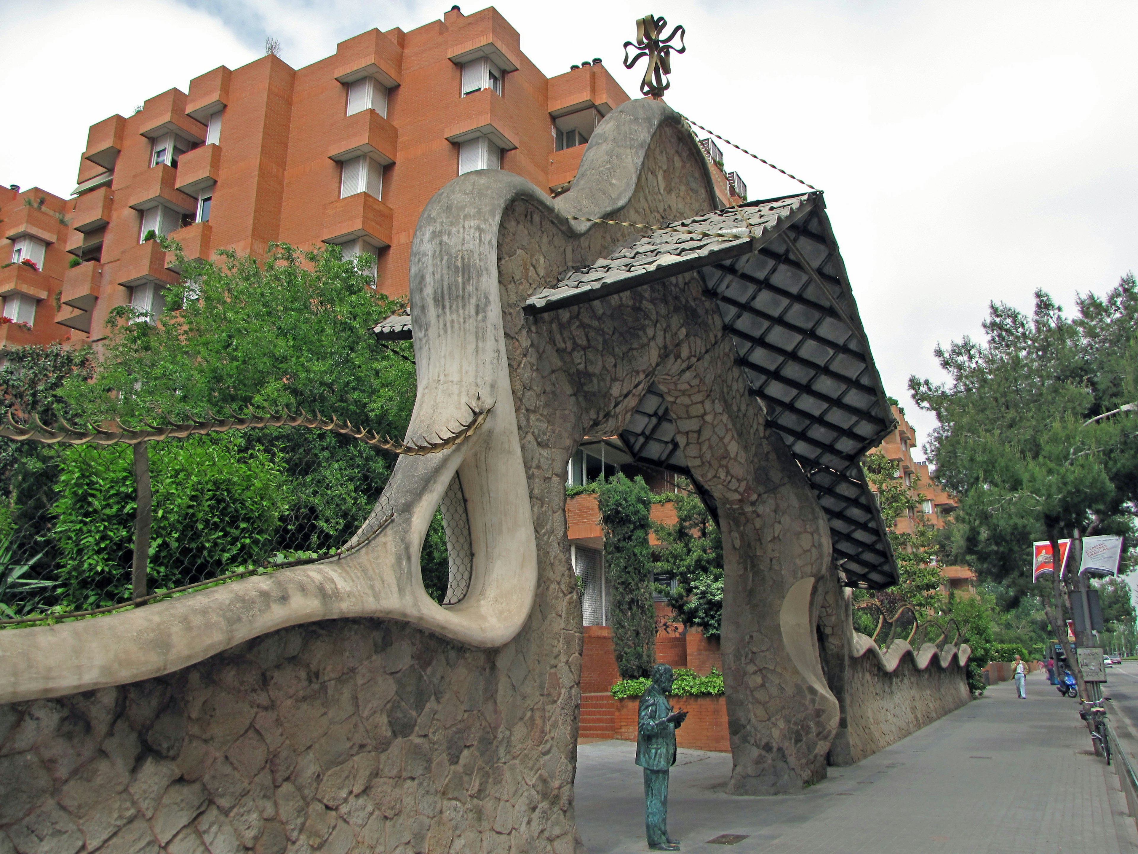 Porta d'ingresso curva unica circondata da verde e edifici