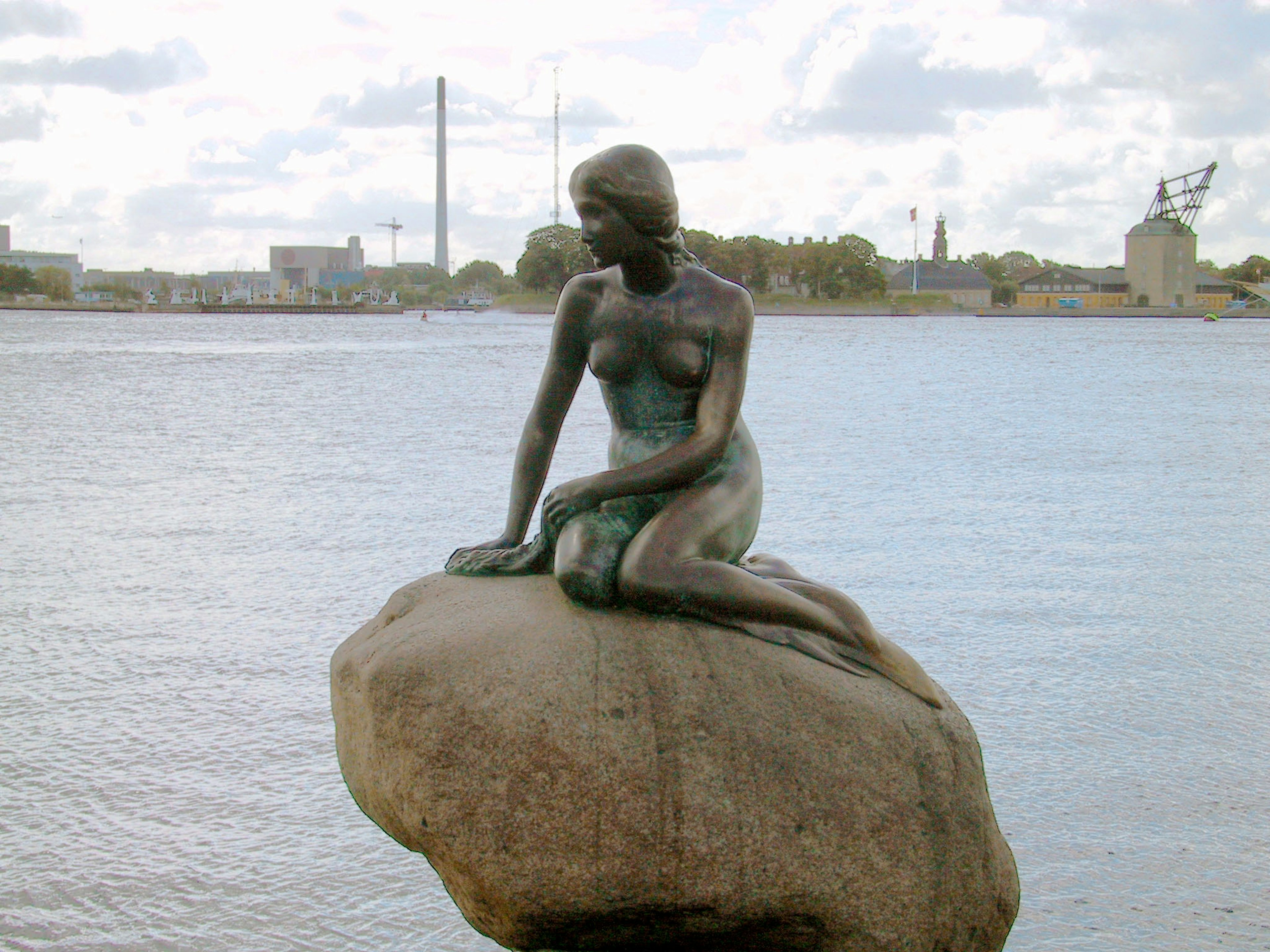 Die Kleine Meerjungfrau Statue in Kopenhagen sitzt auf einem Stein am Wasser