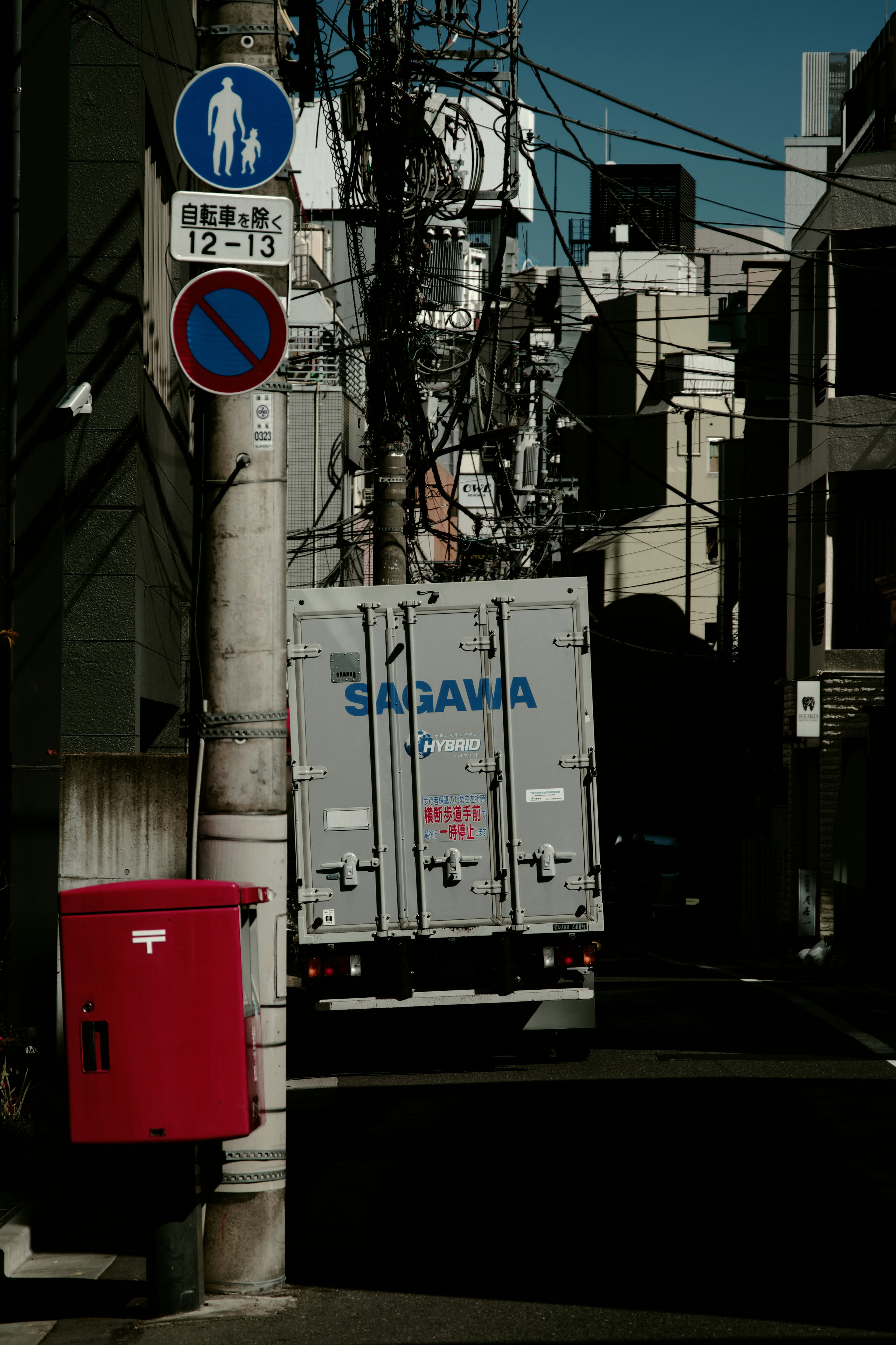 Ansicht eines Saragawa-Lkw, der in einer engen Gasse mit einem roten Briefkasten parkt