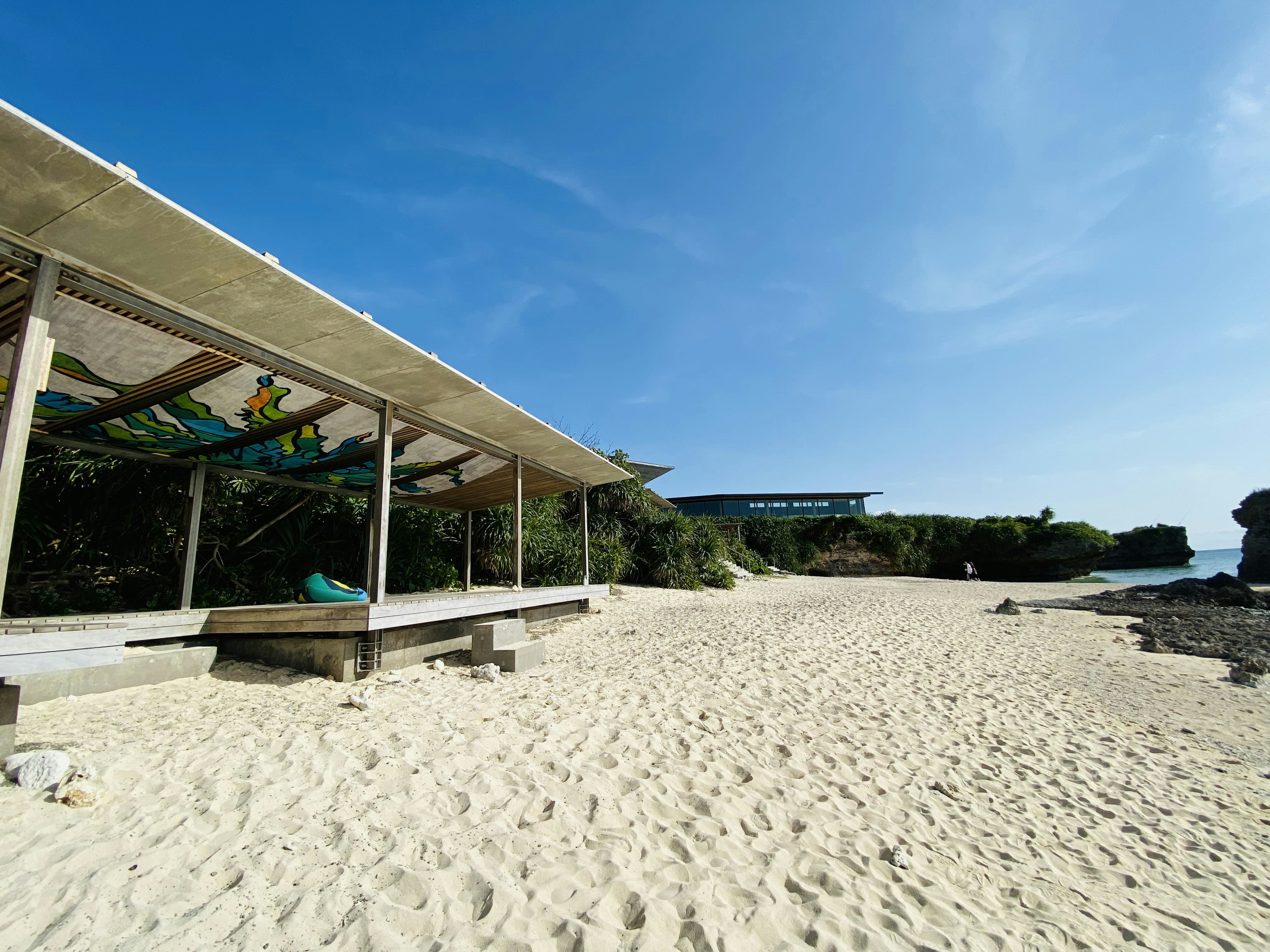 Strandpavillon mit weißem Sand und klarem blauen Himmel