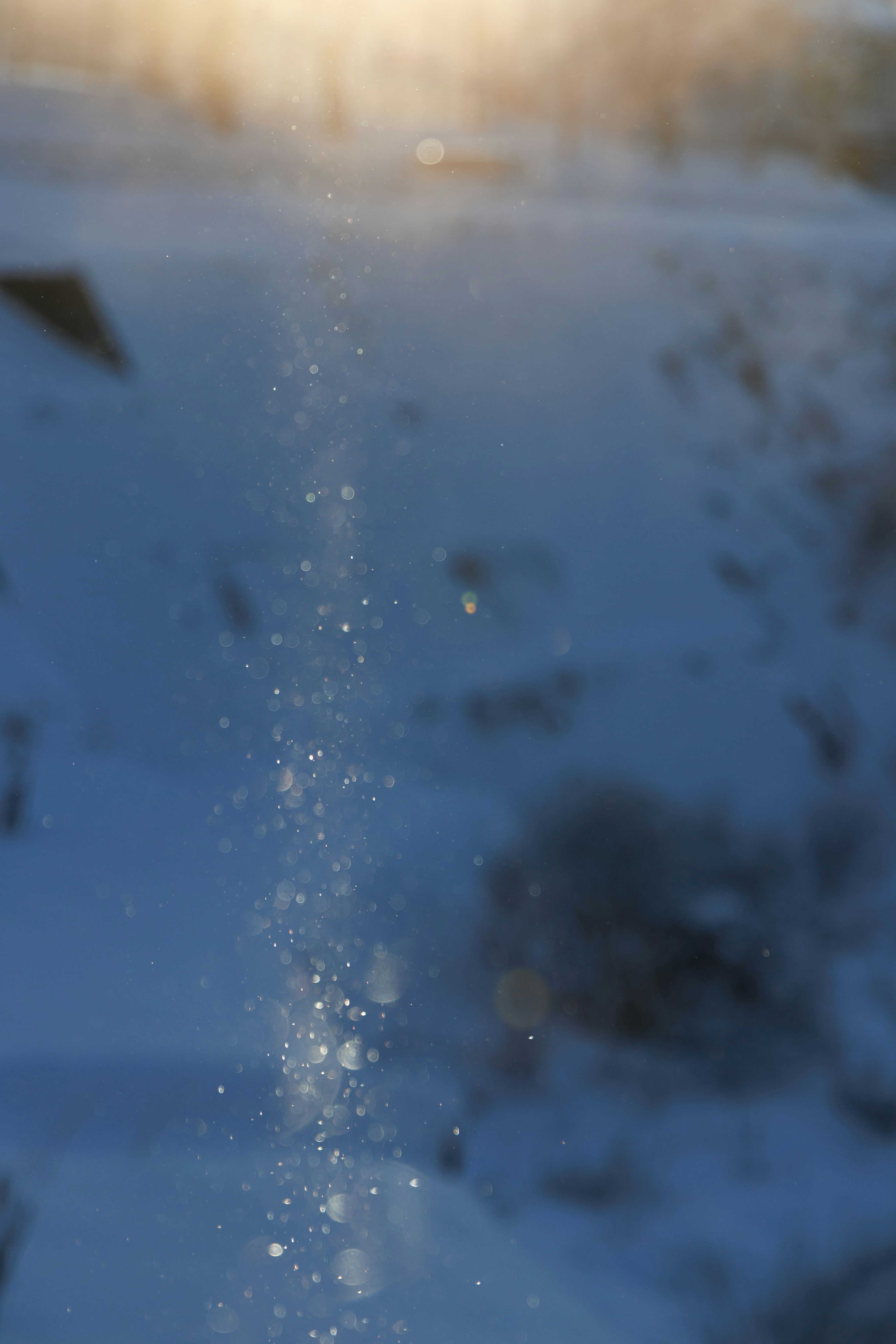 Sparkling particles in snow with a blurred background landscape