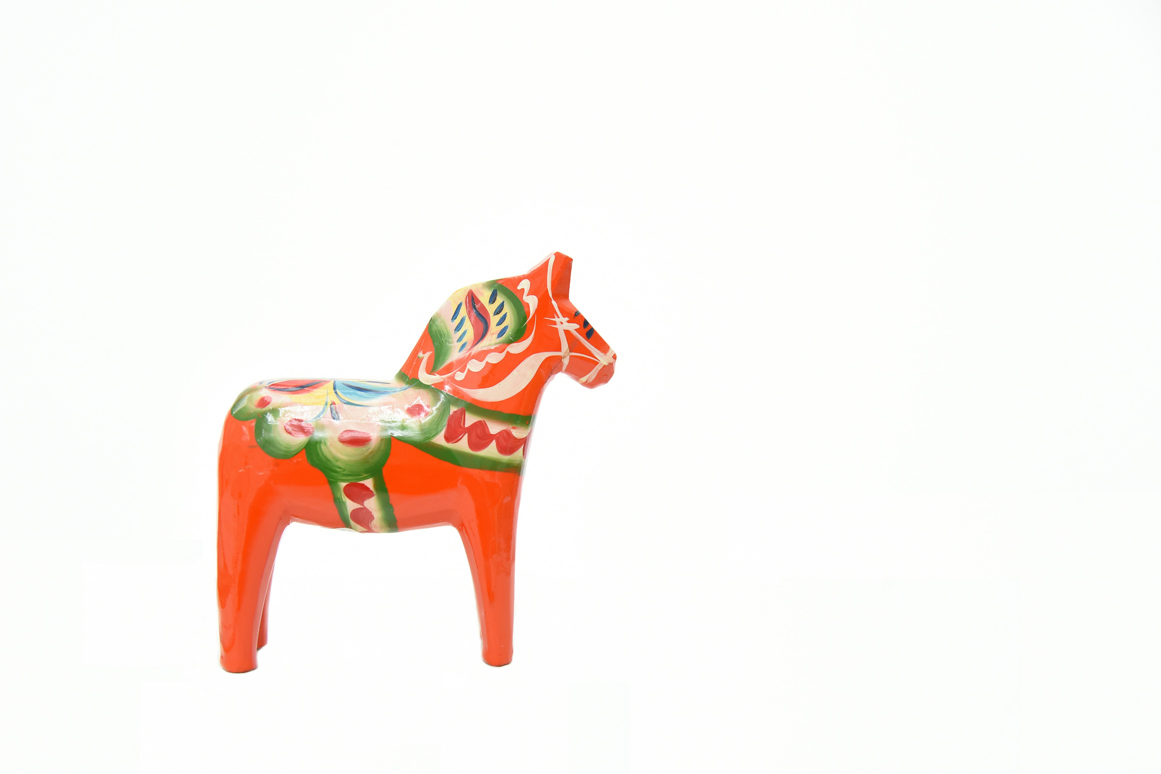 Colorful painted wooden horse figurine in orange and green