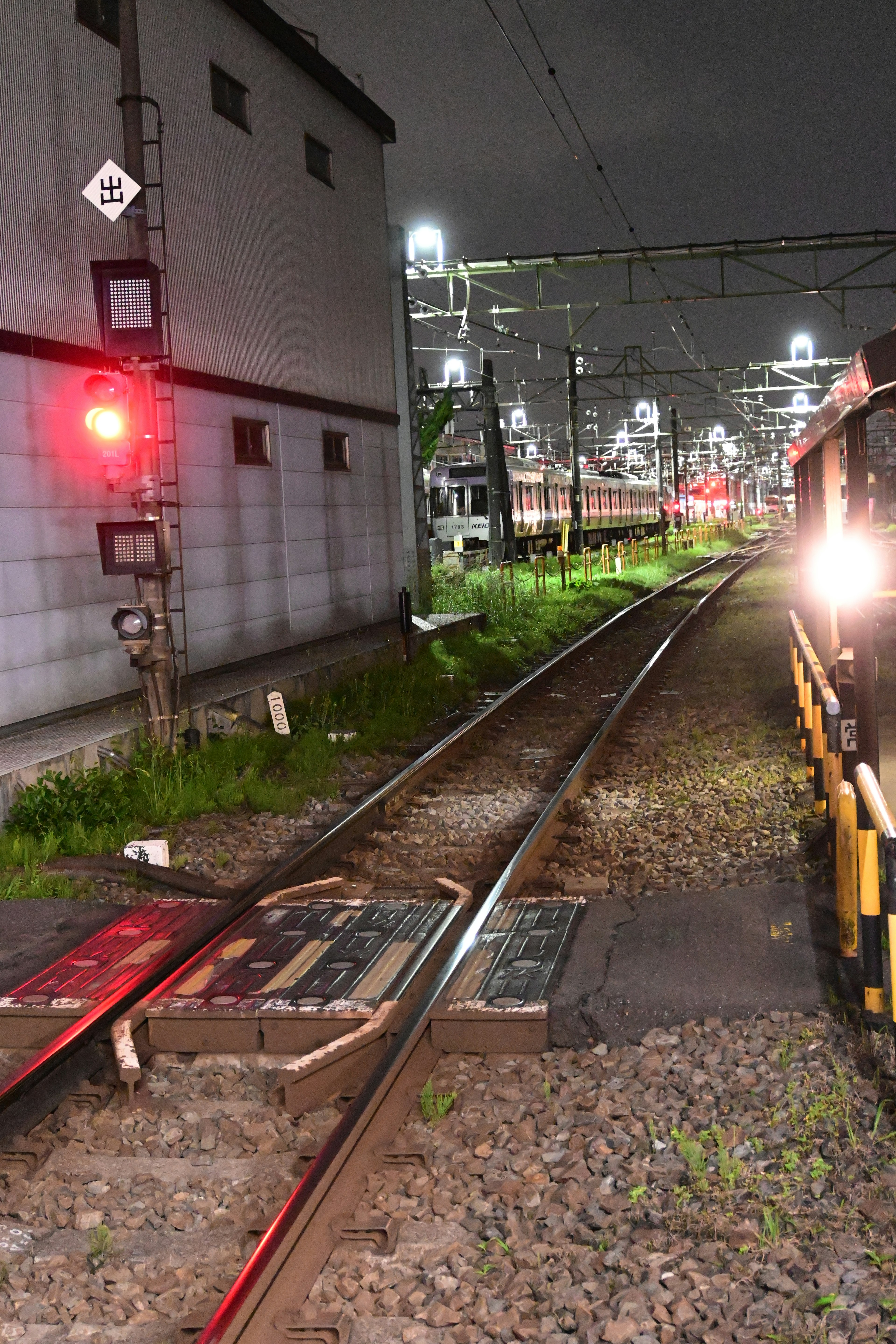 Nighttime railway scene featuring a red signal and tracks