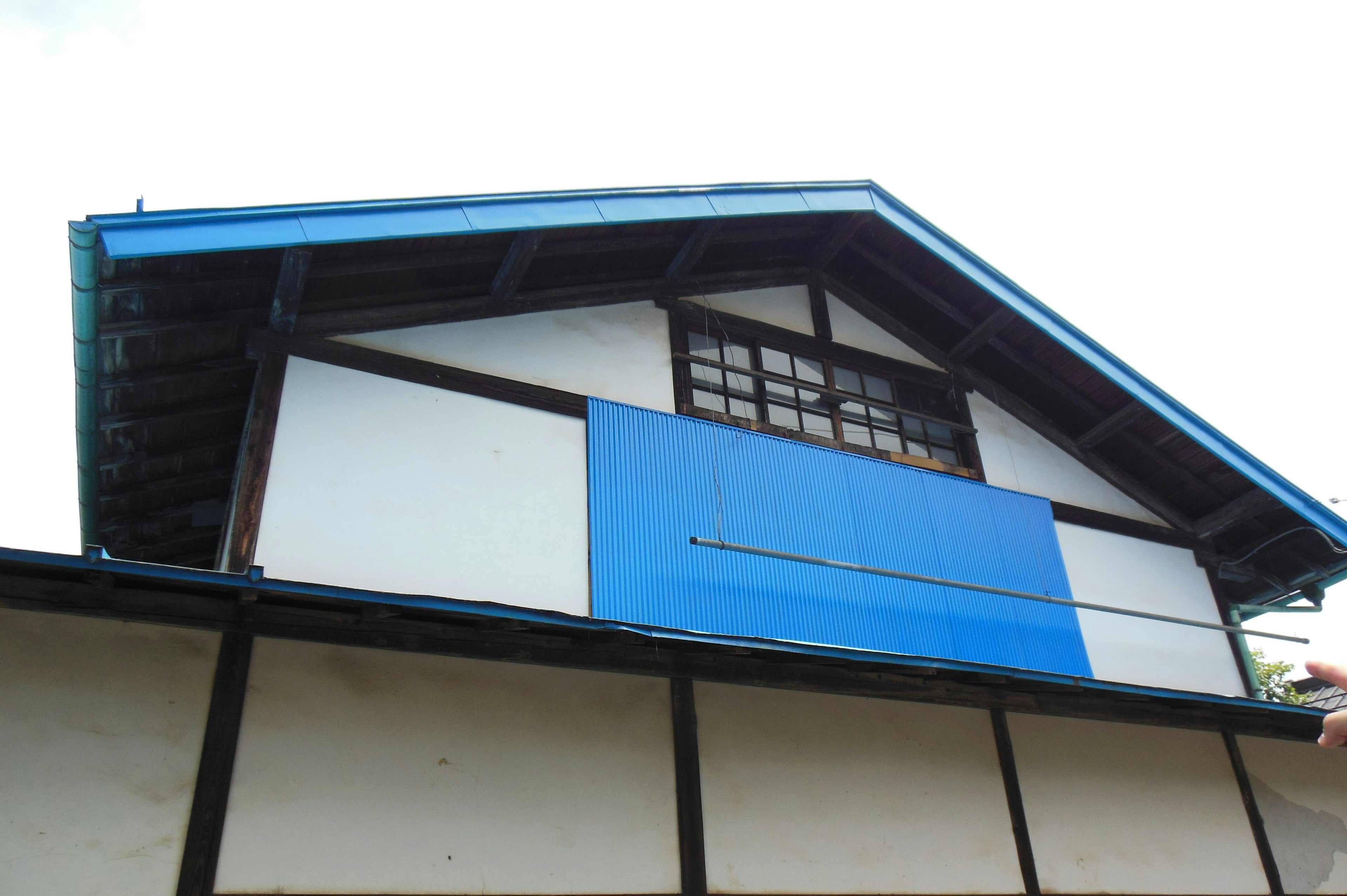 Exterior de una casa japonesa tradicional con un techo azul