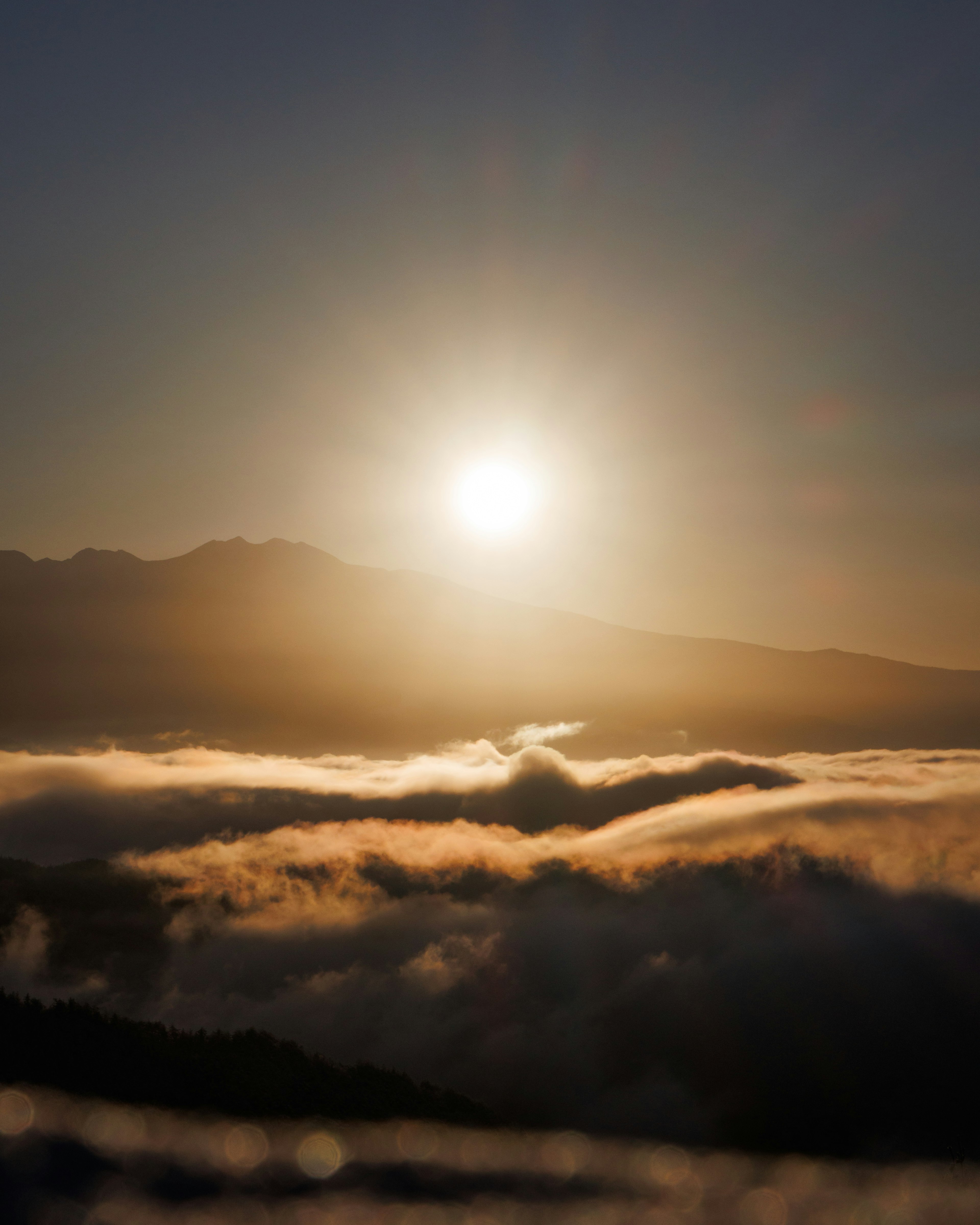 Lever de soleil sur des sommets montagneux avec une mer de nuages