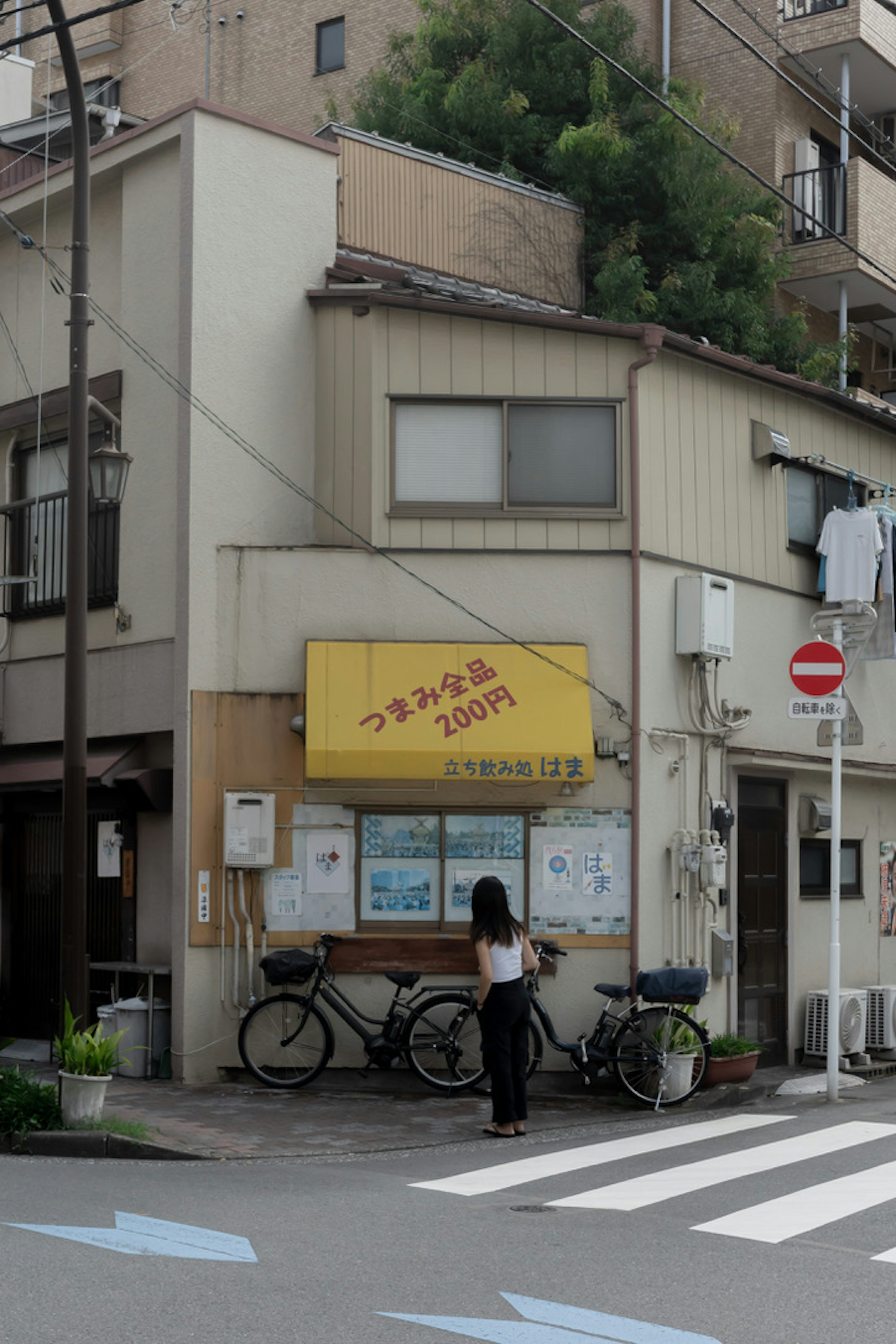 黄色い看板のある小さな店の外観と自転車