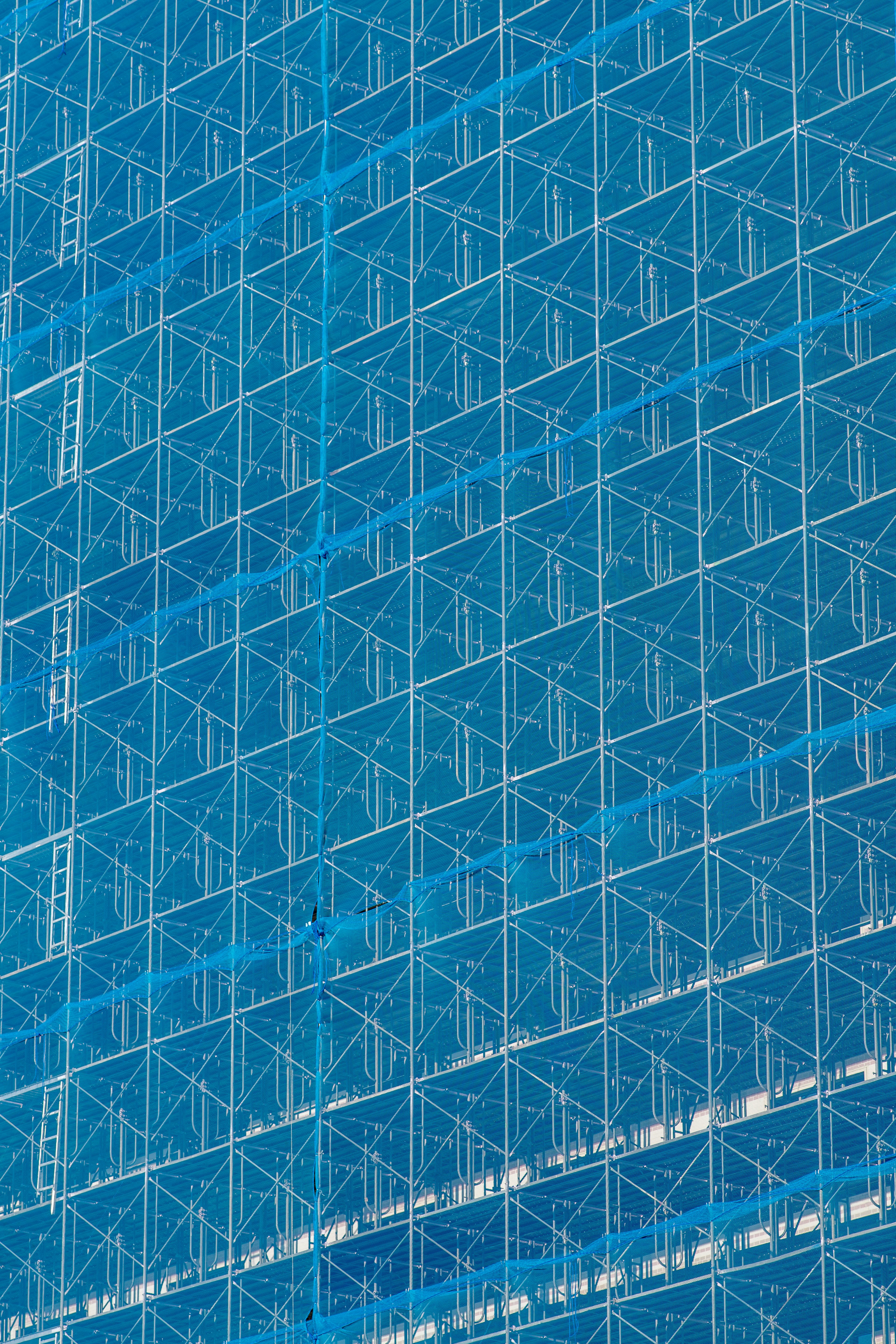 Motif géométrique en treillis sur la façade bleue d'un bâtiment