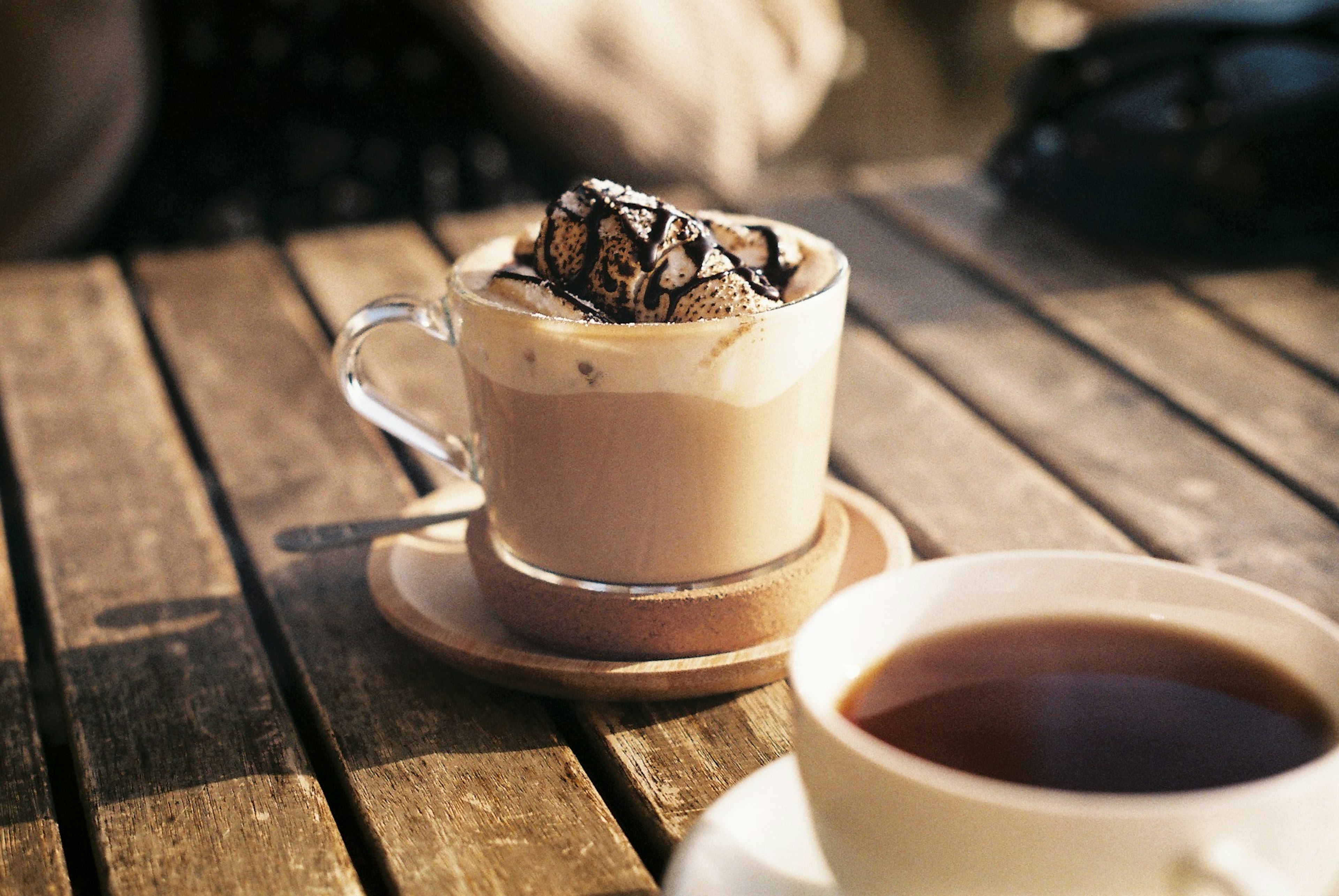 Kaffee mit Sahne und Schokolade auf einem Holztisch