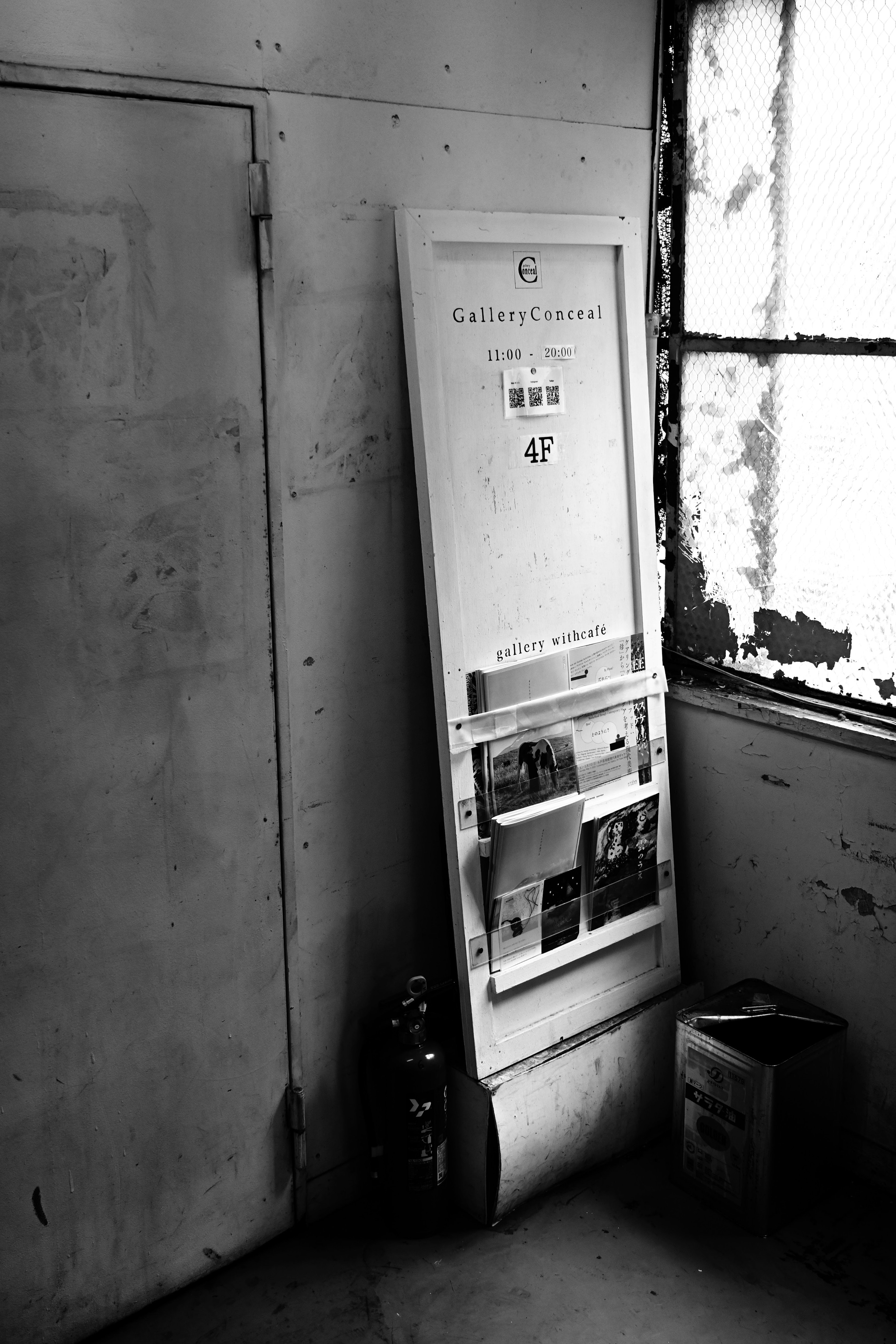 White door leaning against the wall in an old room with sunlight streaming through the window