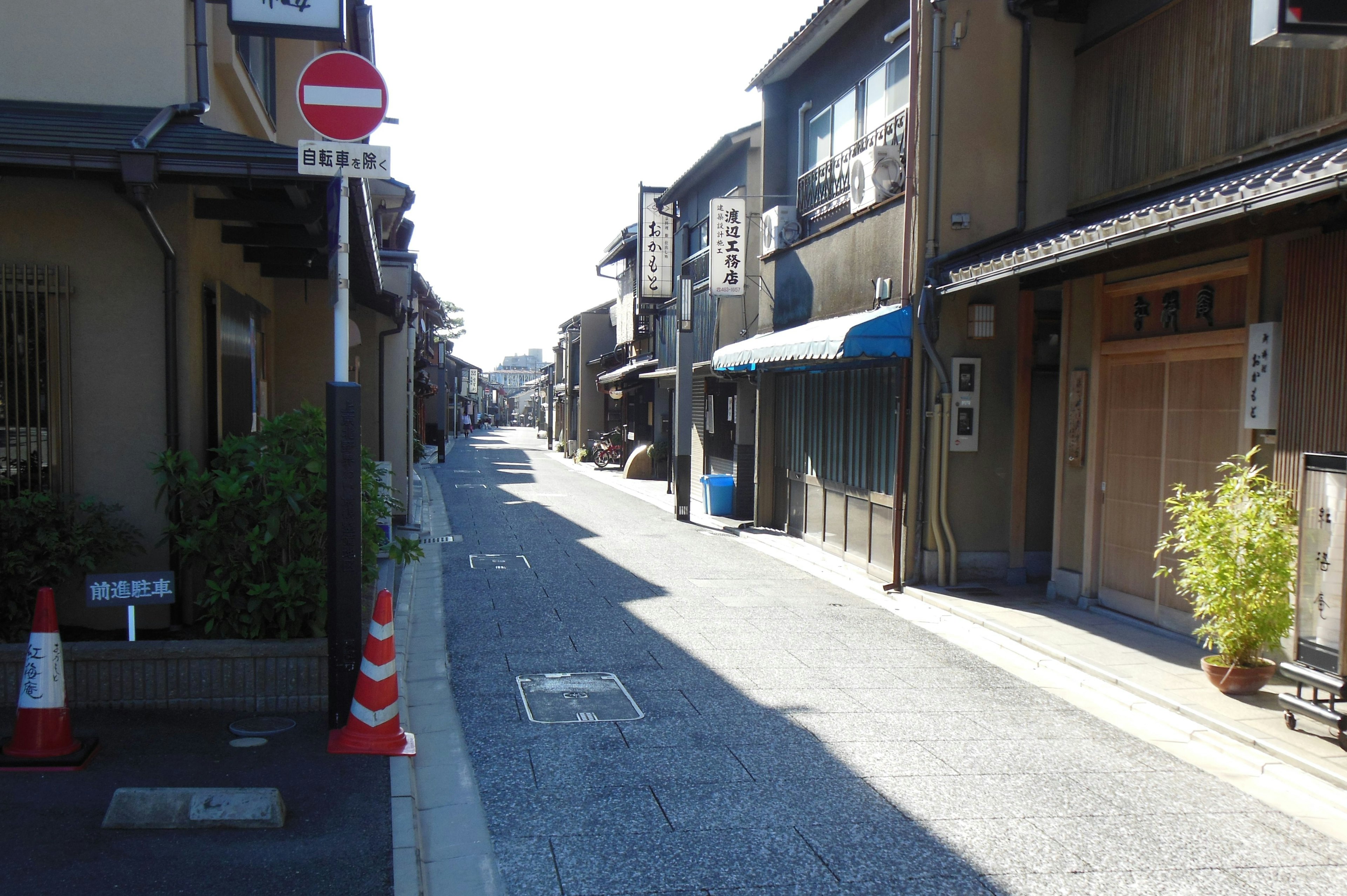 Calle estrecha con edificios tradicionales y una tienda de techo azul