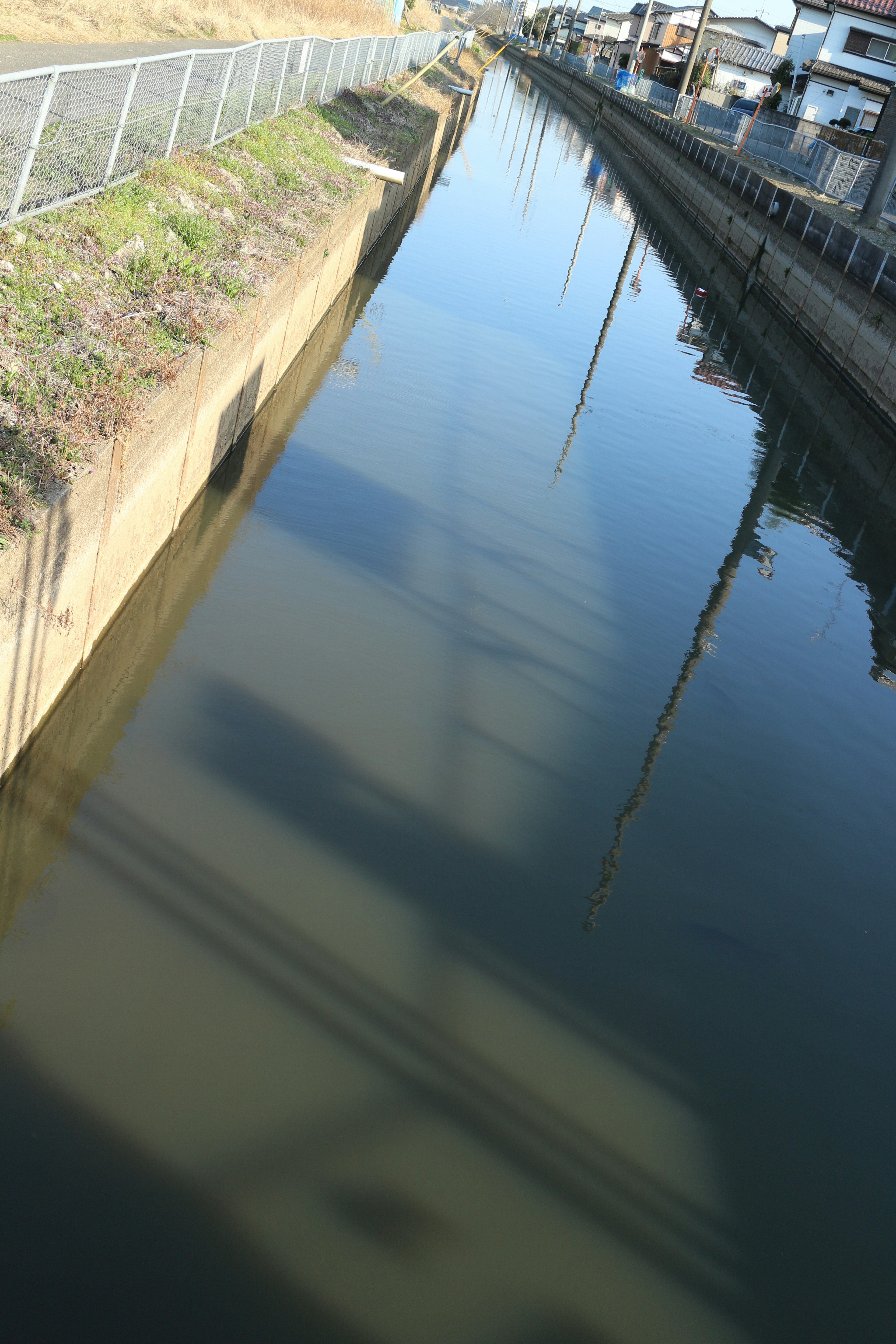 Una vista de un canal que refleja sombras y estructuras circundantes