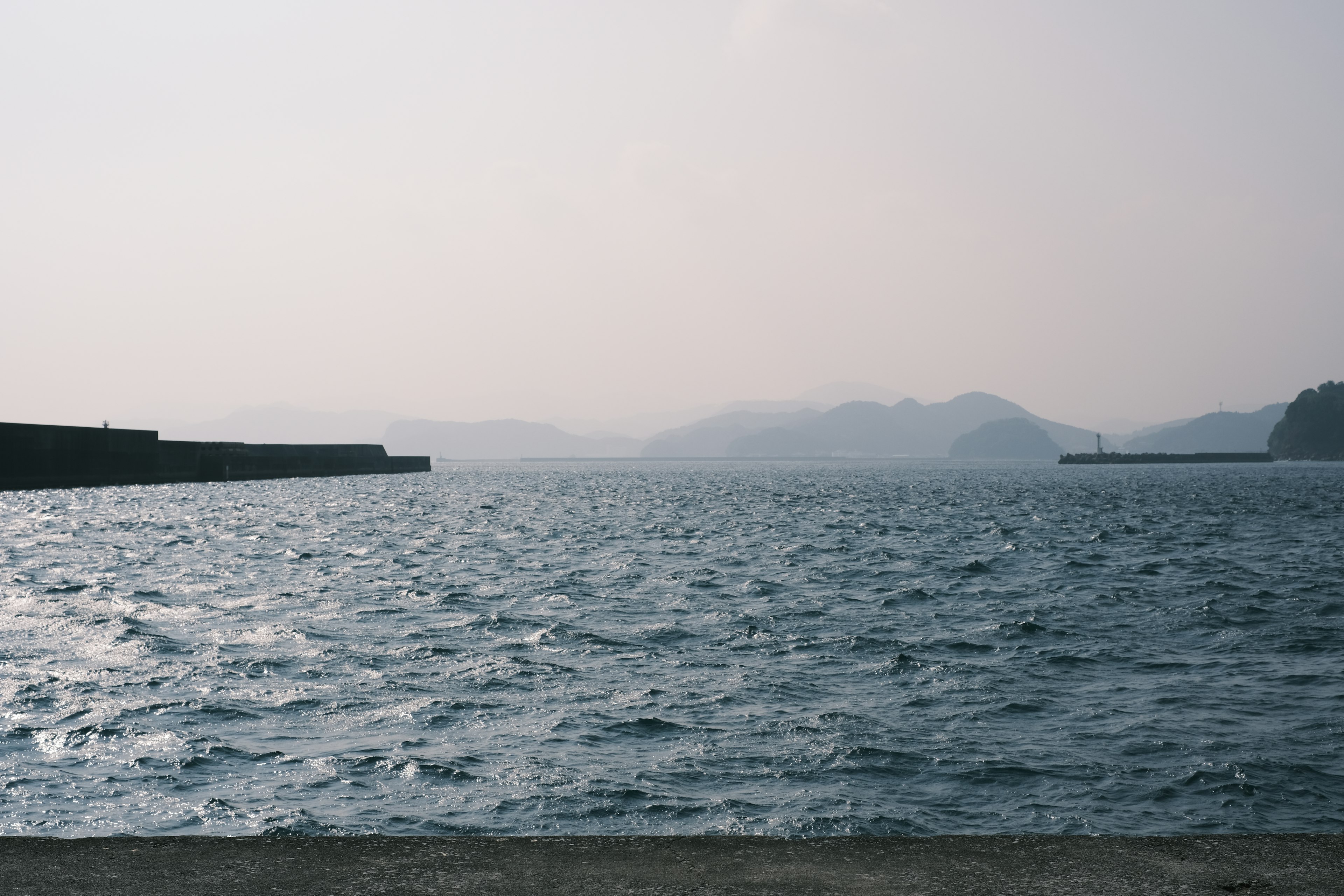 Calm sea with distant mountains in the background