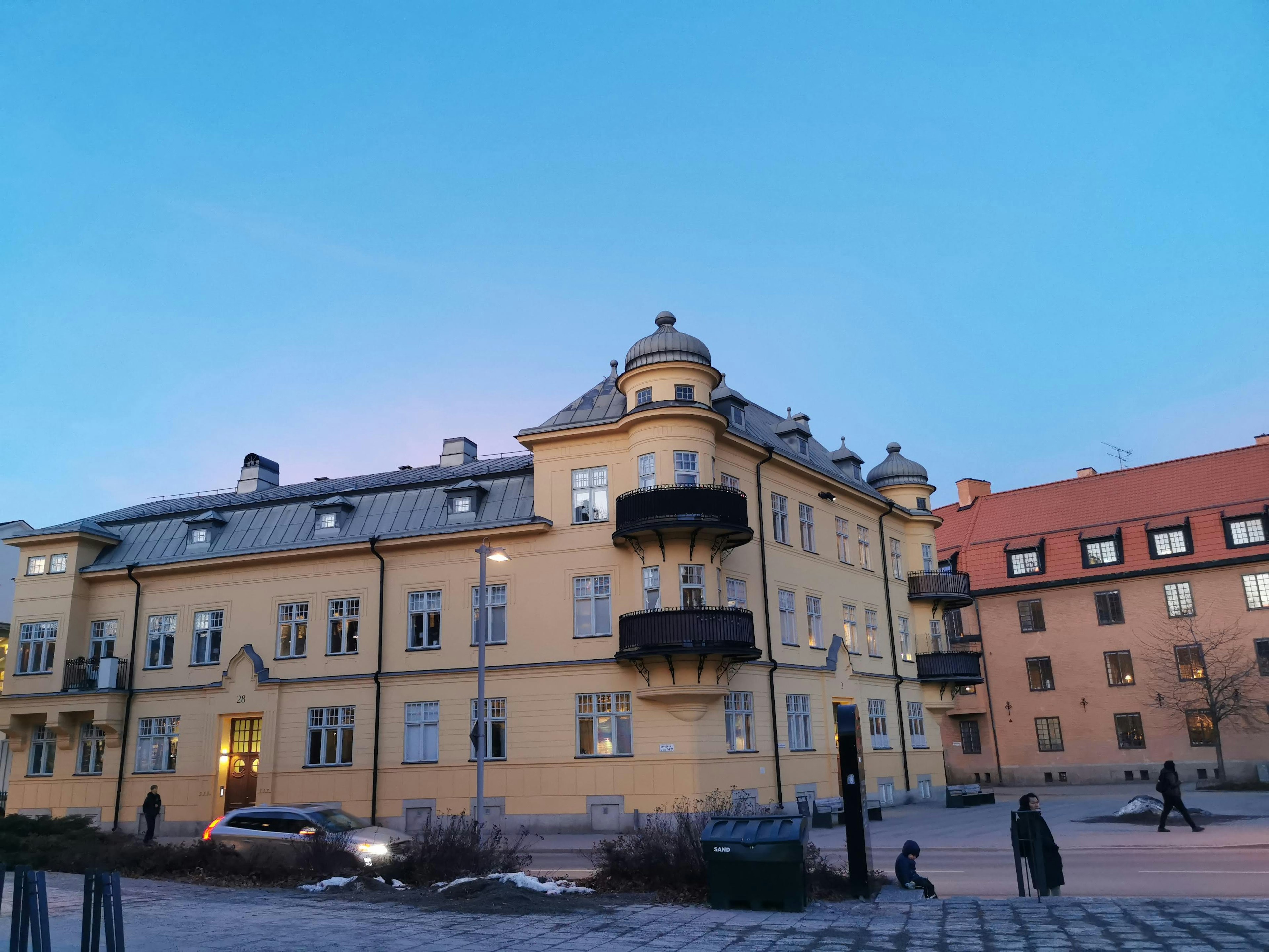 Schönes gelbes Gebäude mit Balkonen unter blauem Himmel