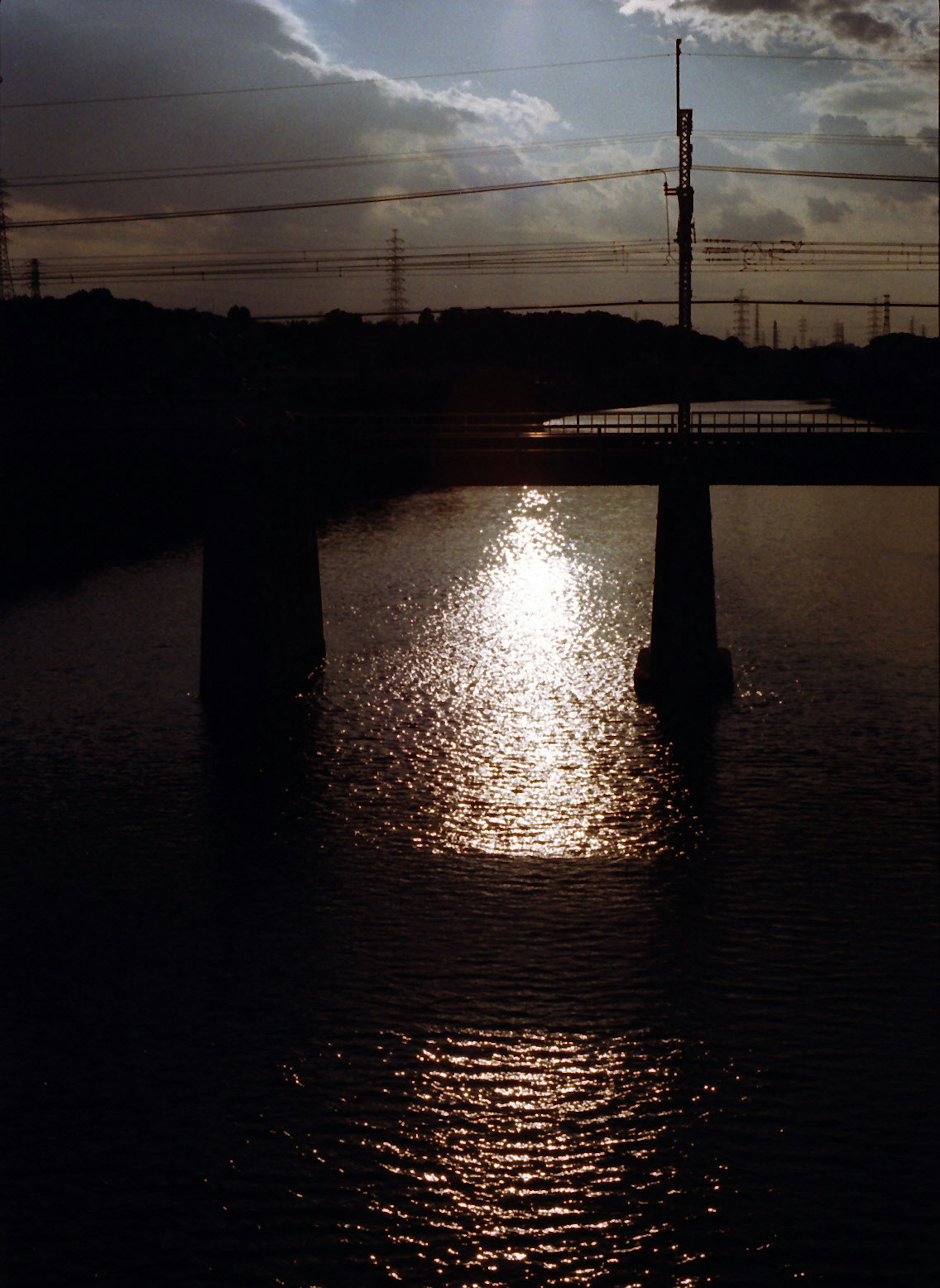 Silhouette of a bridge with sunset reflection on the water