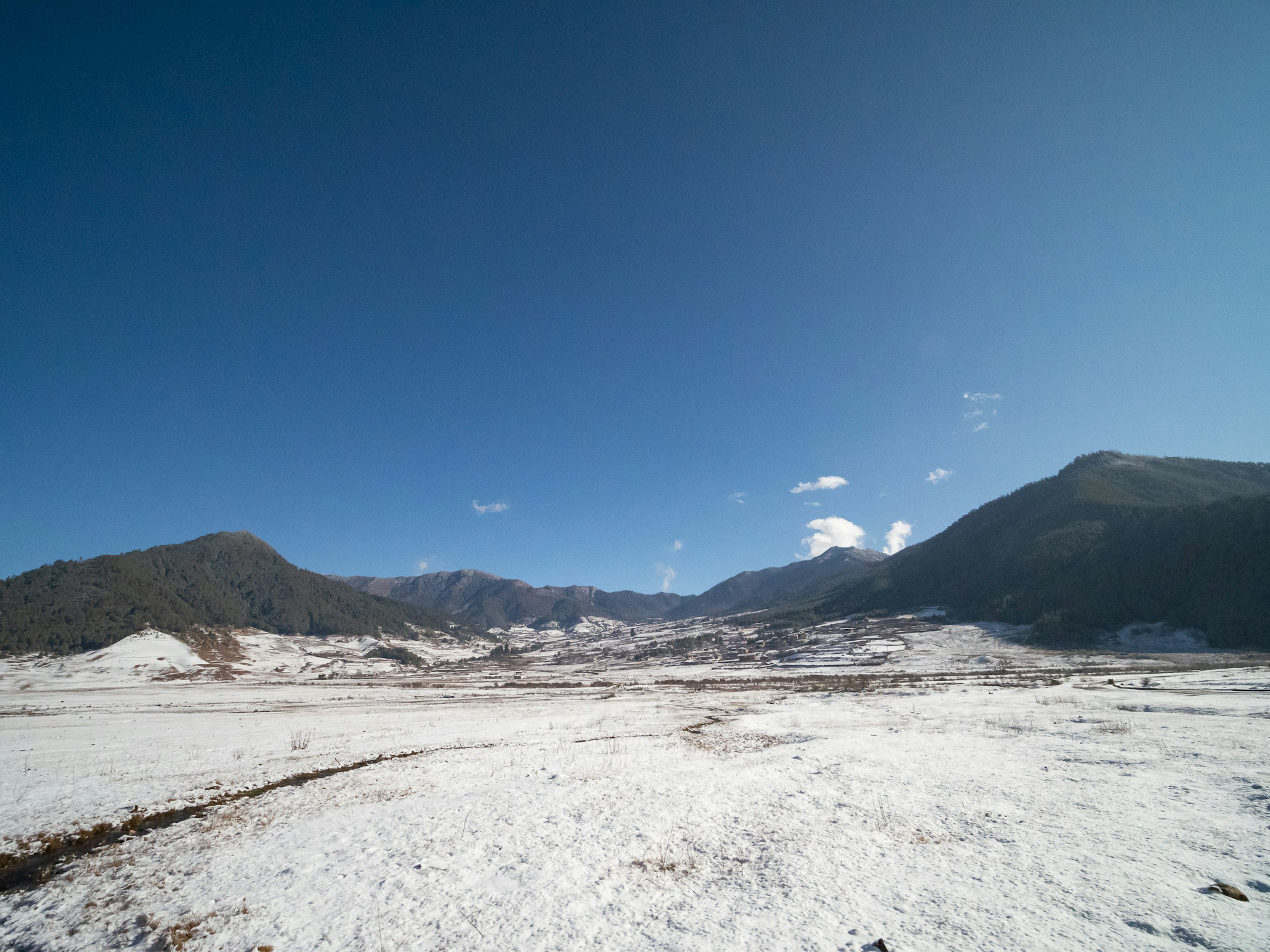 Weite verschneite Landschaft unter einem klaren blauen Himmel