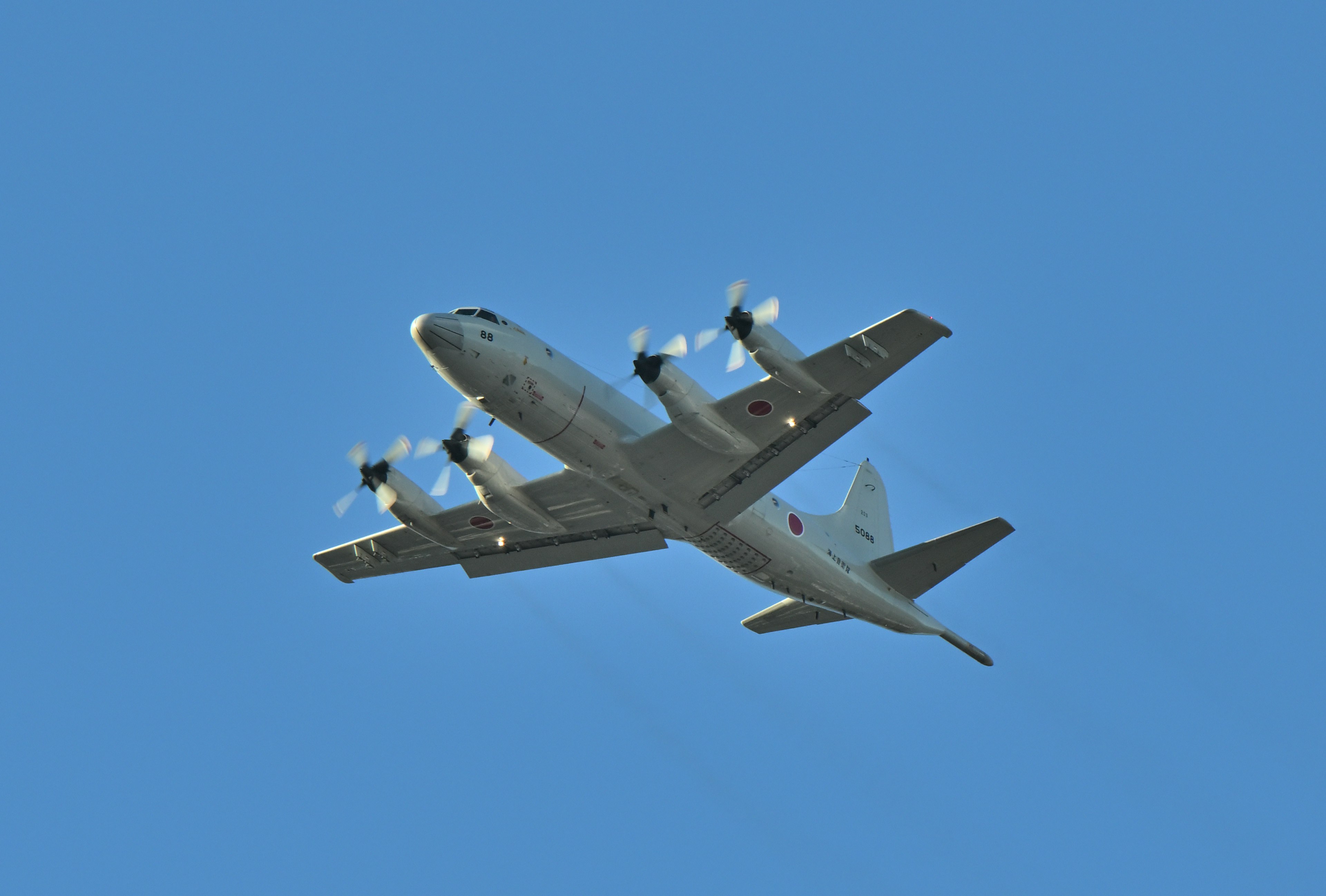 Propeller aircraft flying against a clear blue sky