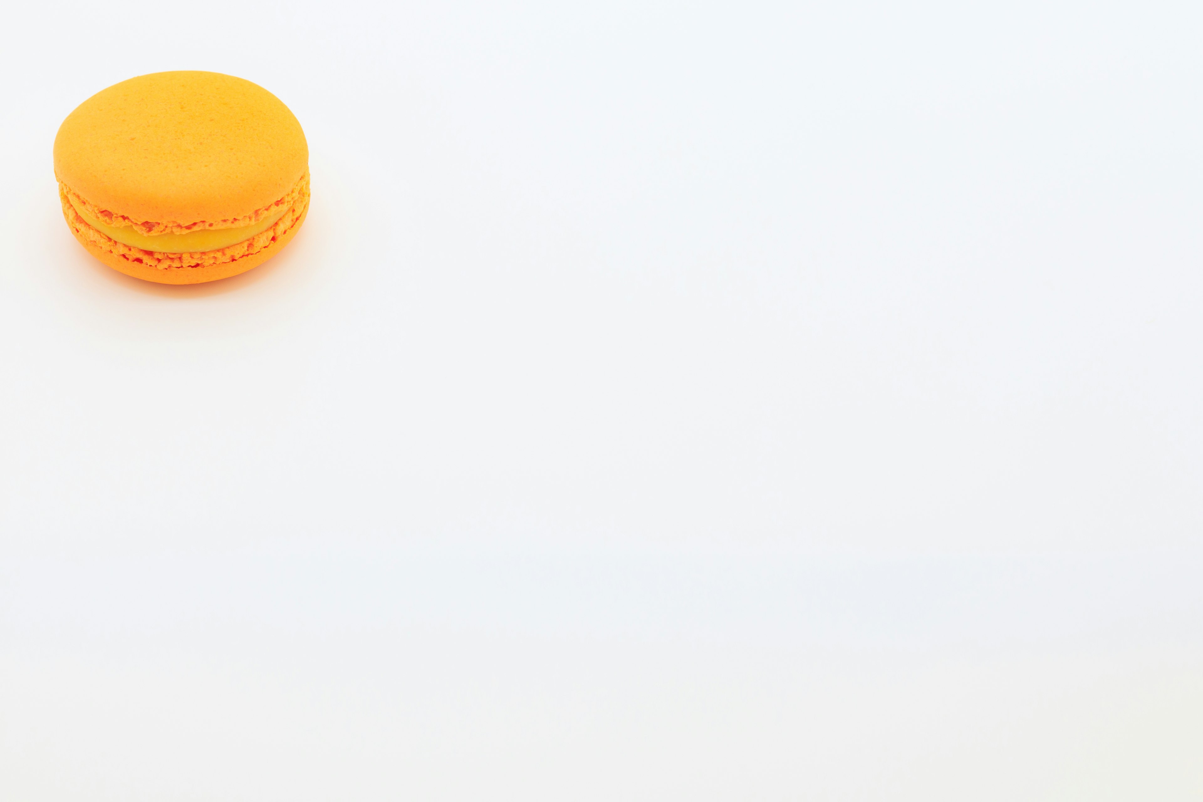 Un macaron orange sur un fond blanc