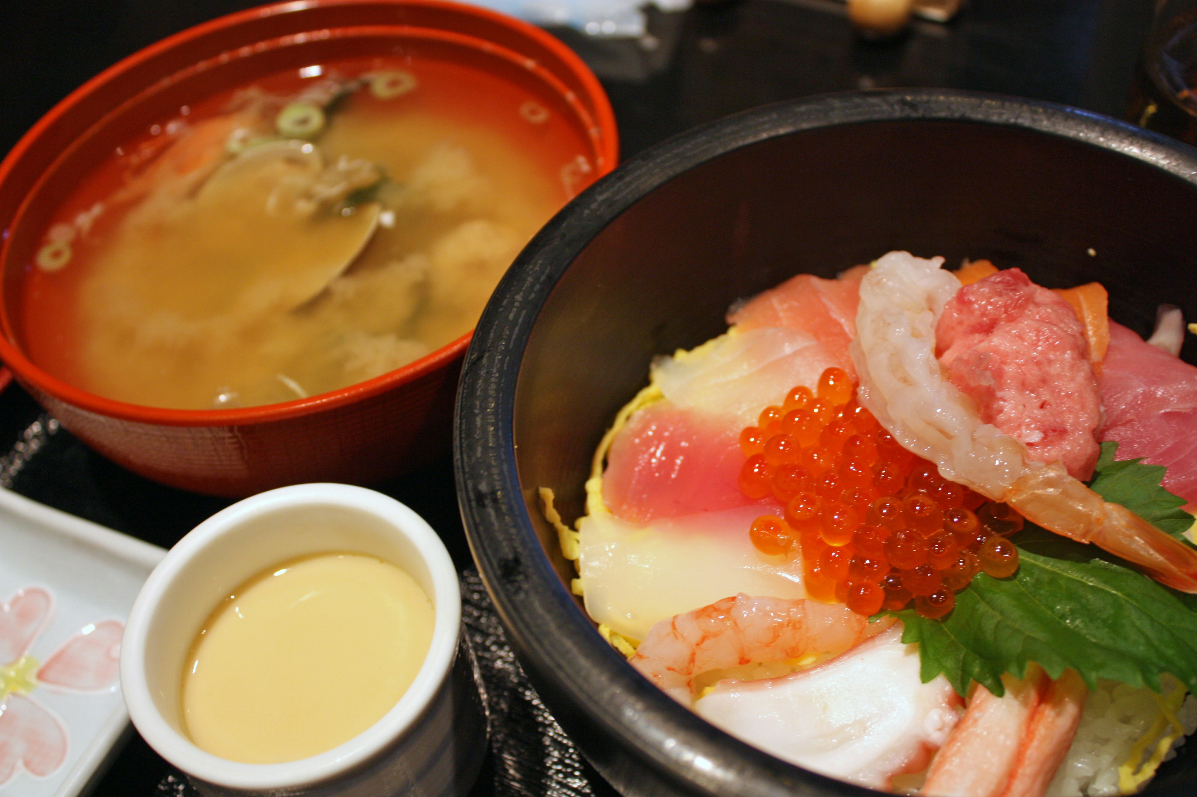 Seafood rice bowl with miso soup featuring fresh fish and salmon roe