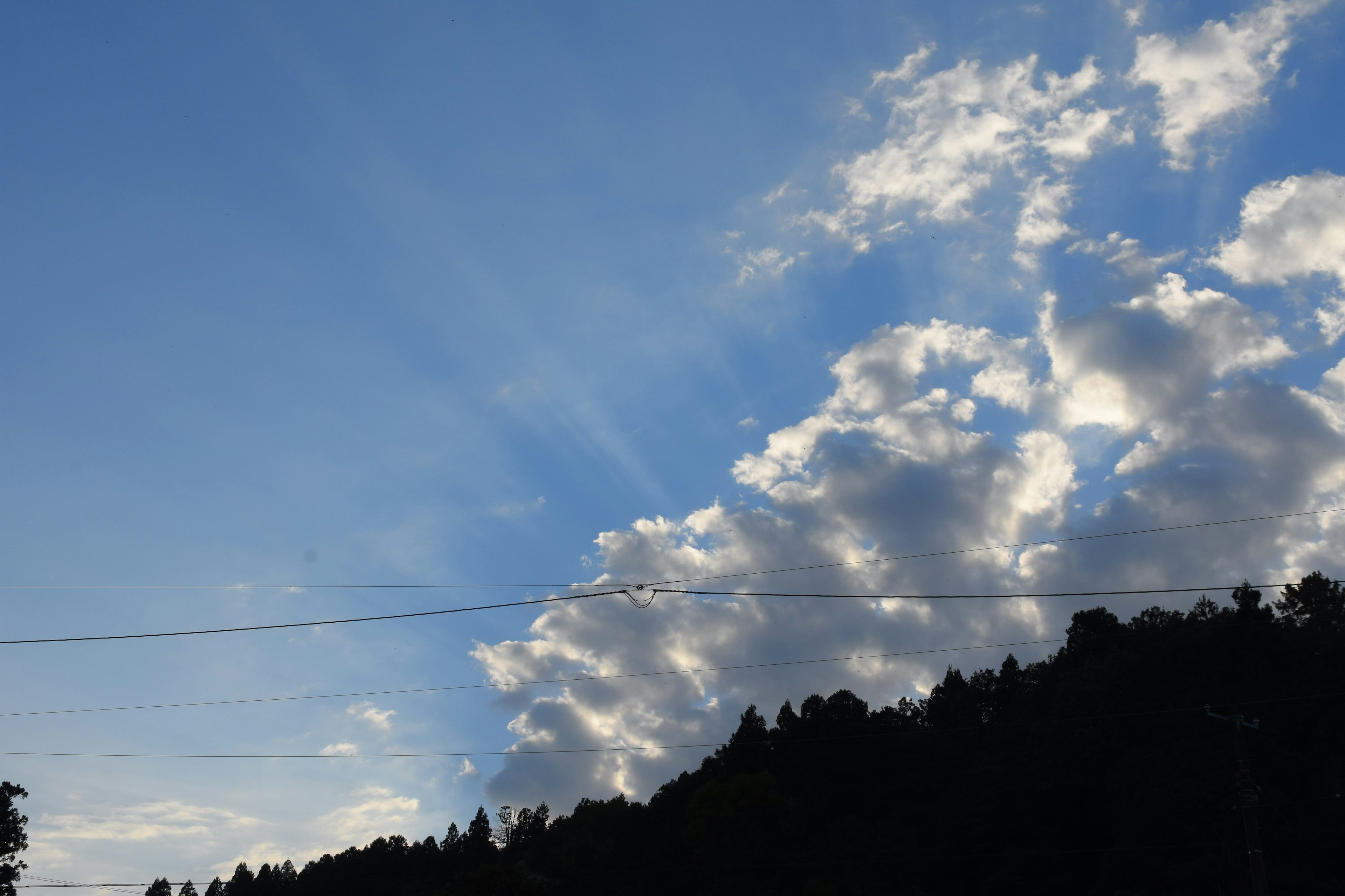 Cielo azul brillante con nubes blancas y montañas distantes visibles