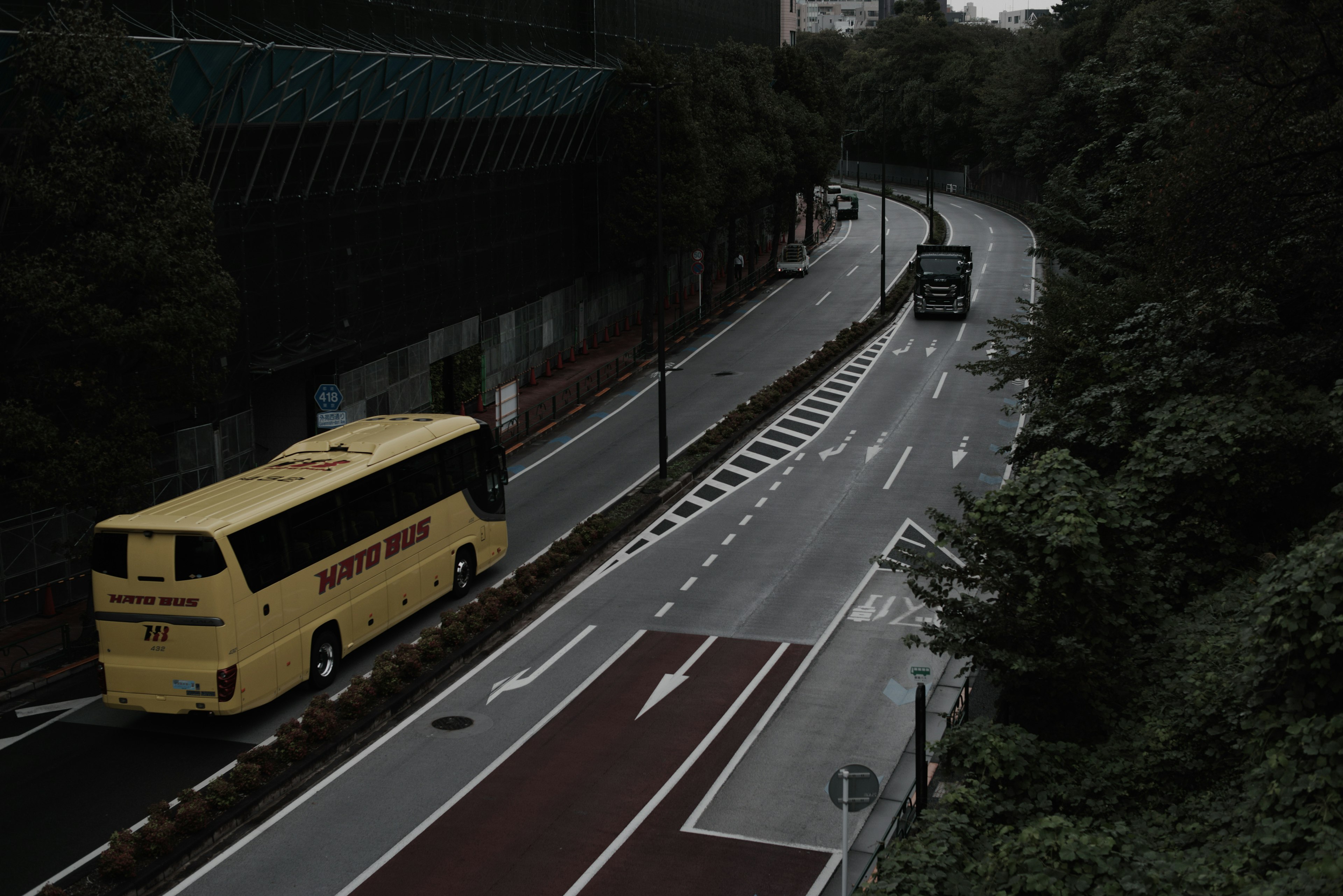 Gelber Bus auf einer kurvenreichen Straße umgeben von Grün