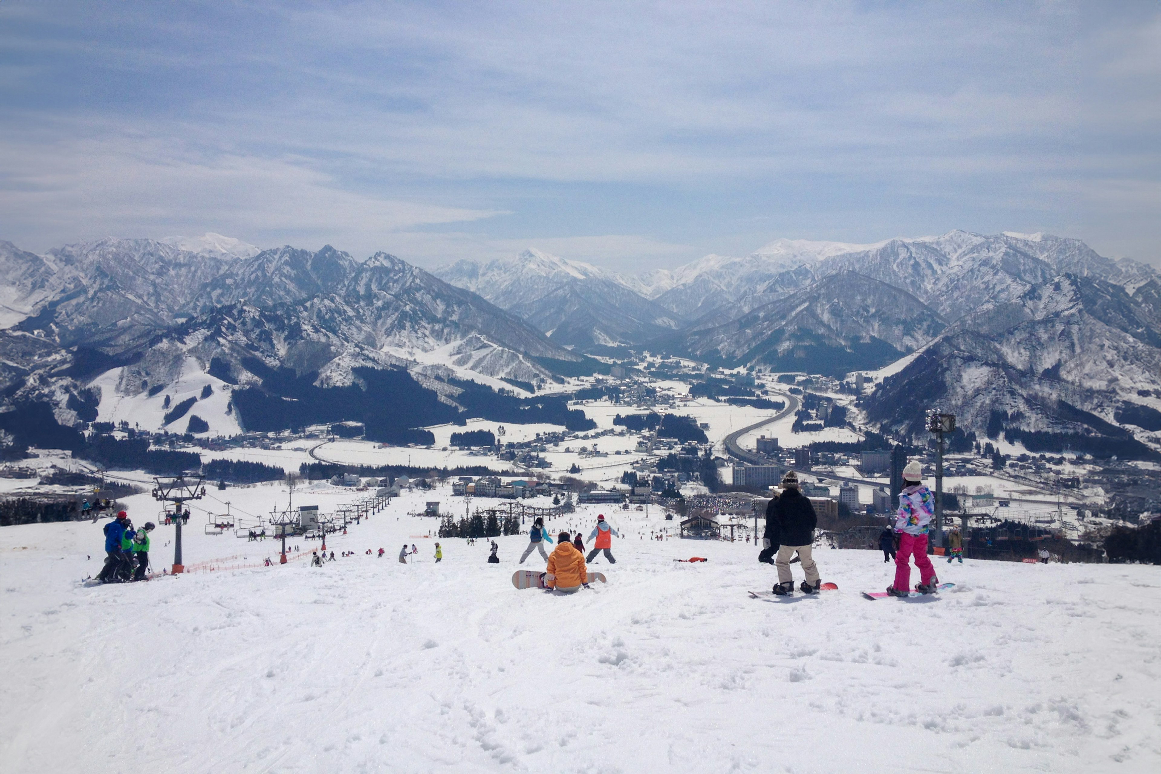 Pemain ski menikmati pemandangan pegunungan bersalju dengan puncak jauh