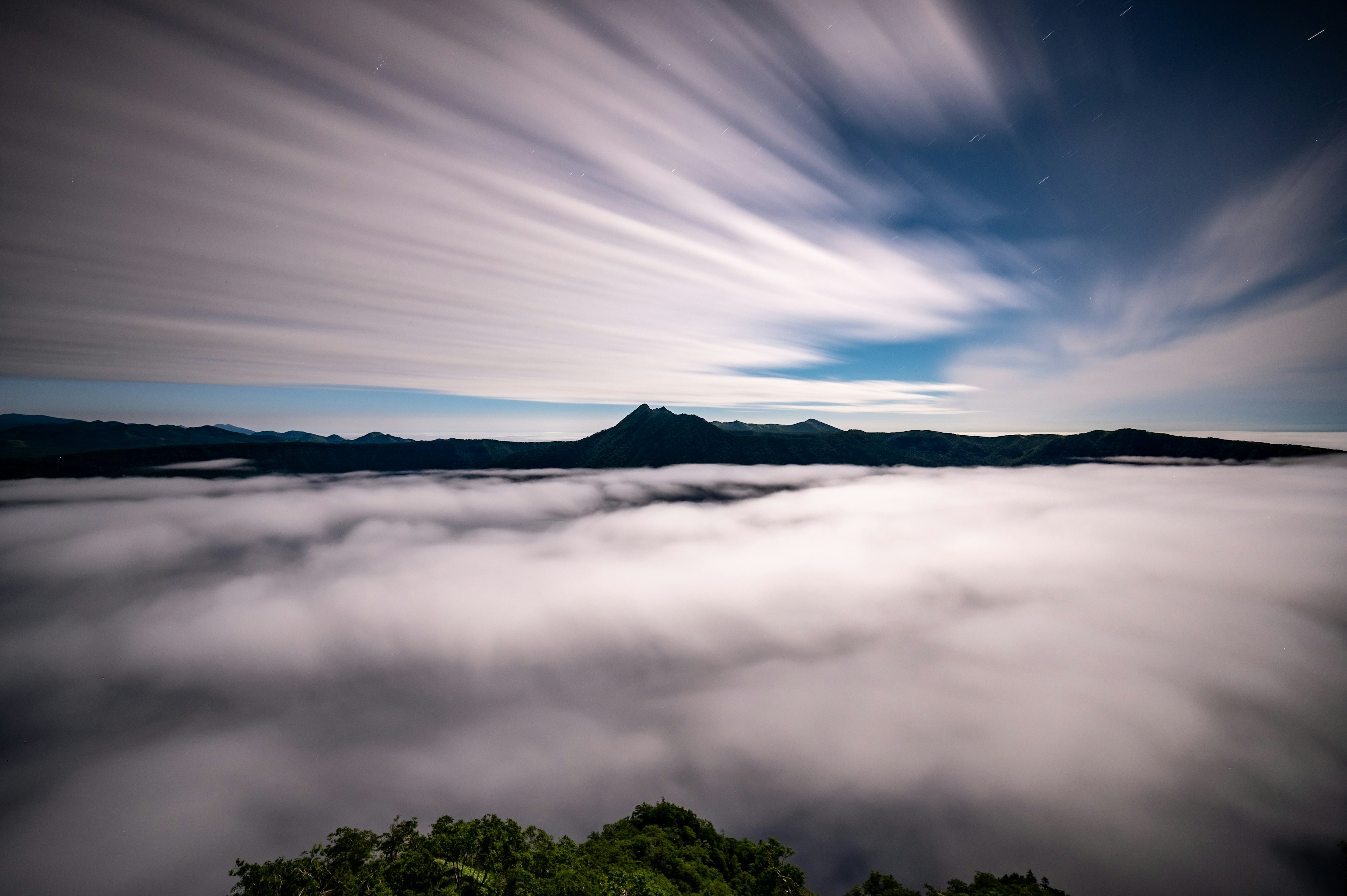 Paysage de montagnes au-dessus d'une mer de nuages avec des nuages mouvants