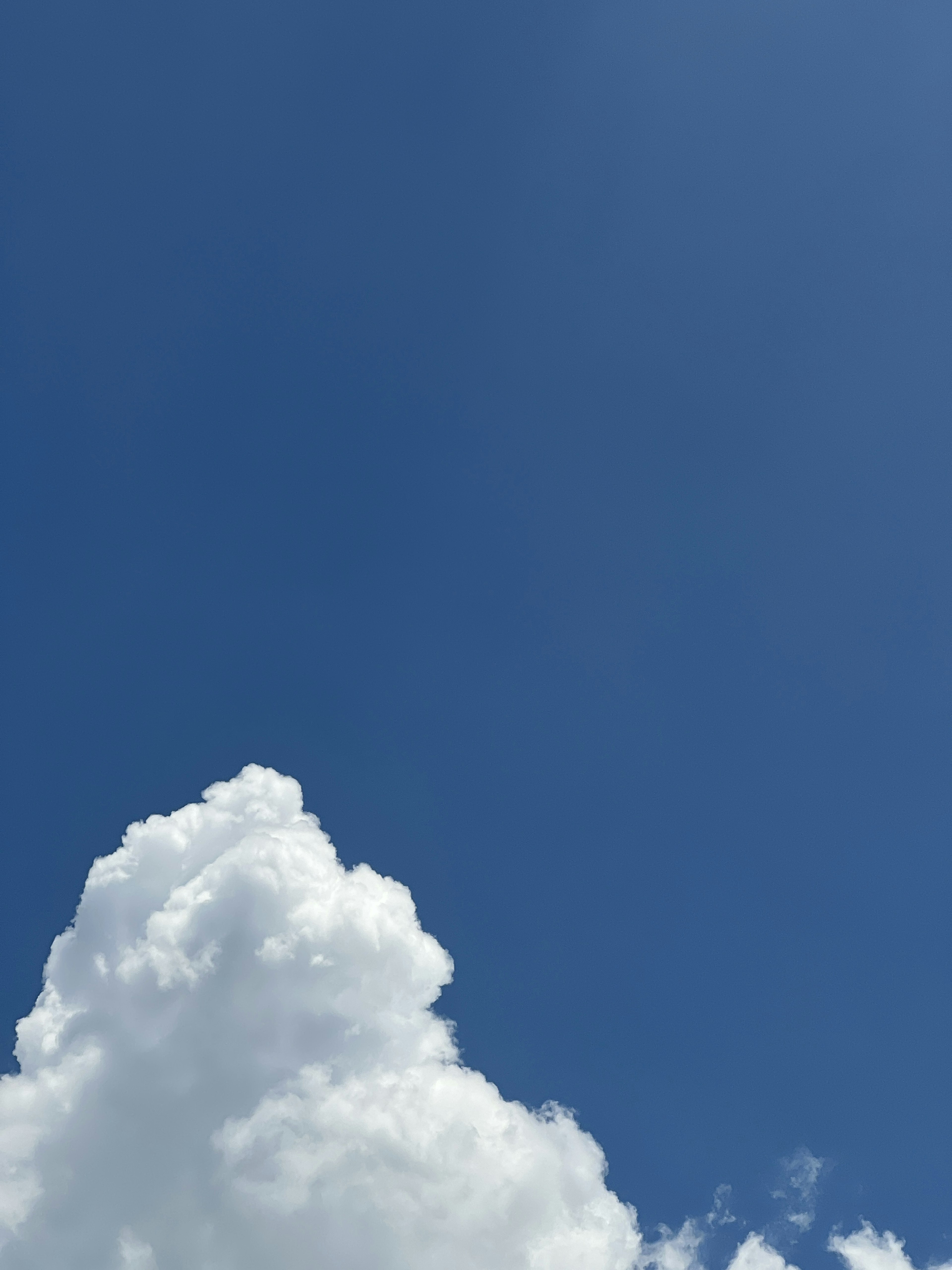 Große flauschige weiße Wolken vor einem klaren blauen Himmel