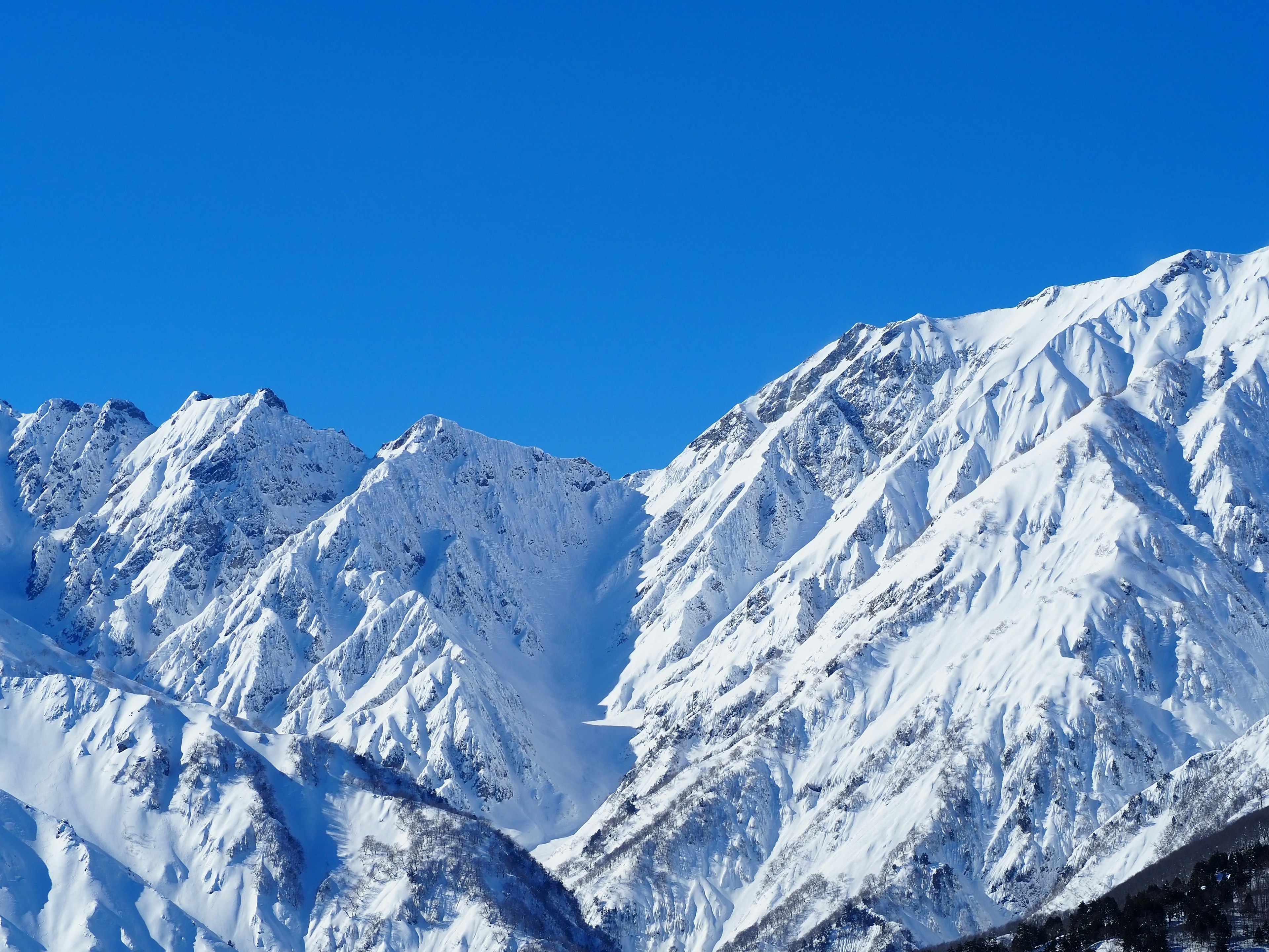 Snow-covered mountains with a clear blue sky