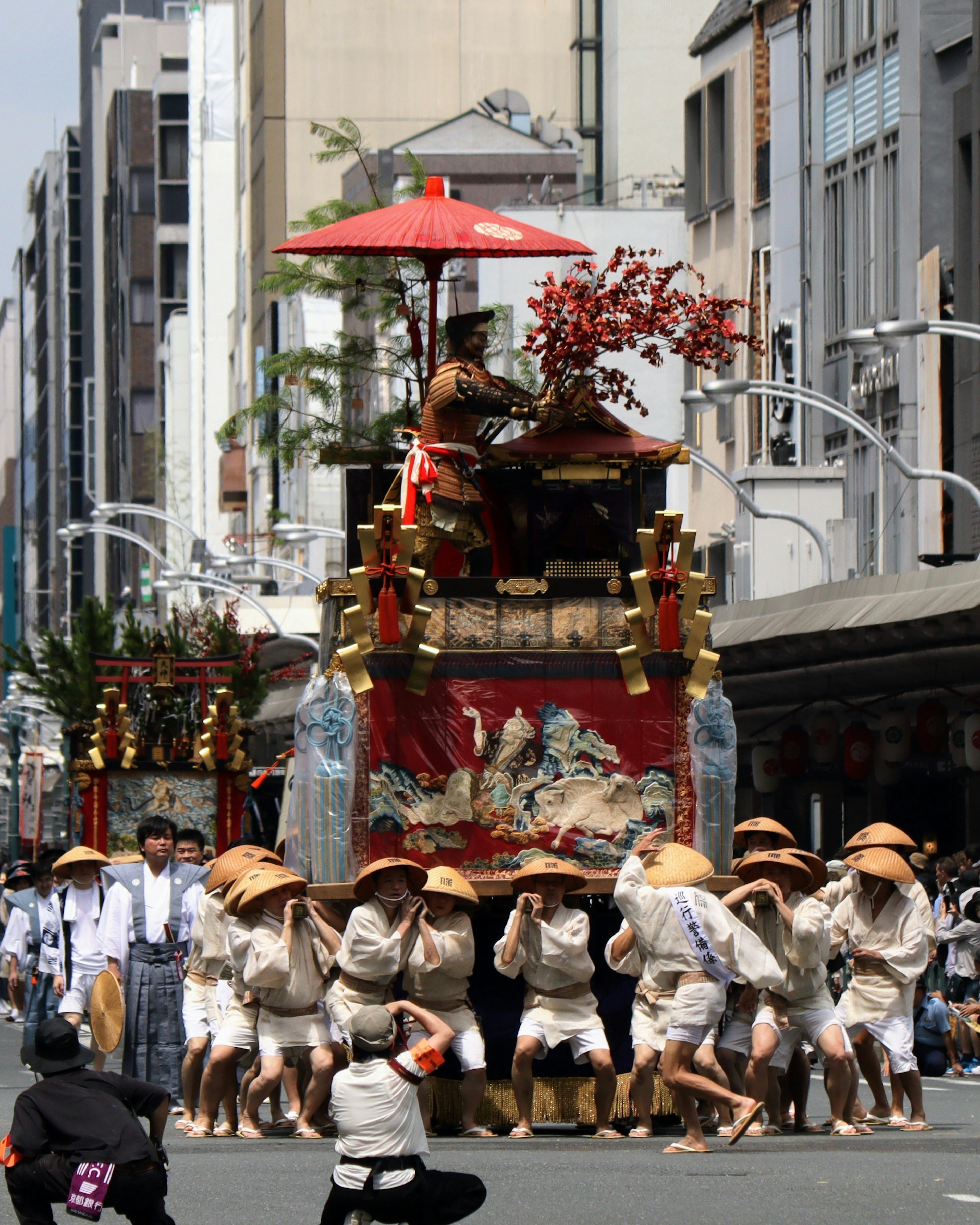 Un carro de festival desfilando por la calle con participantes en atuendos tradicionales